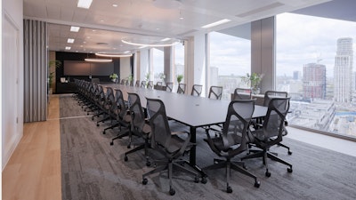 Herman Miller Everywhere conference tables surrounded by high-back Cosm Chairs by Herman Miller with overhead lighting and room dividers in a conference room overlooking London at the NATO Defence Innovation Accelerator