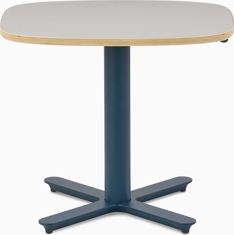 Small Passport Work Table with white surface, plywood edge and dark blue base shown on glides.