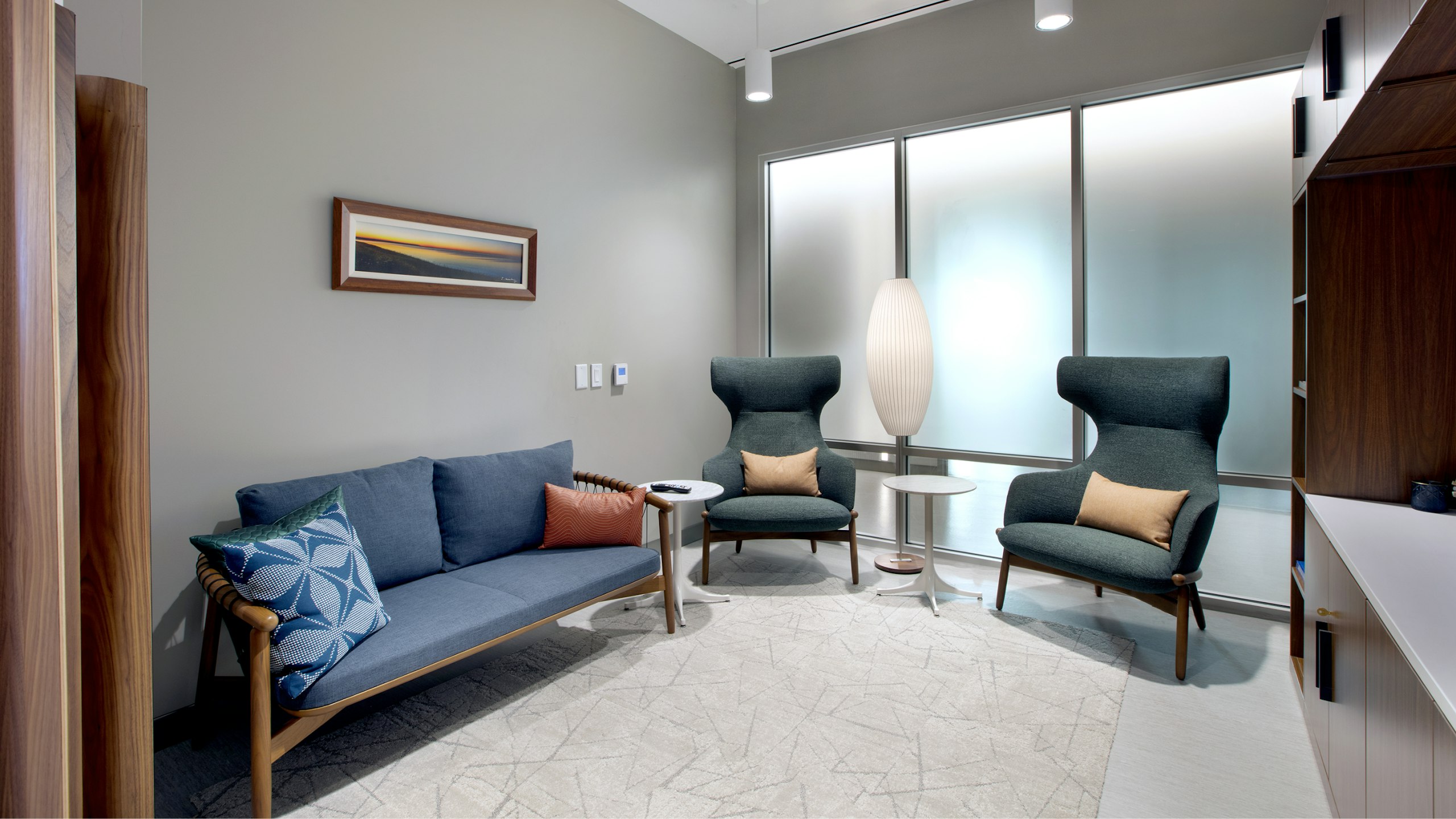 Una sala de espera con un sofá azul y sillas azules en BAMF Health