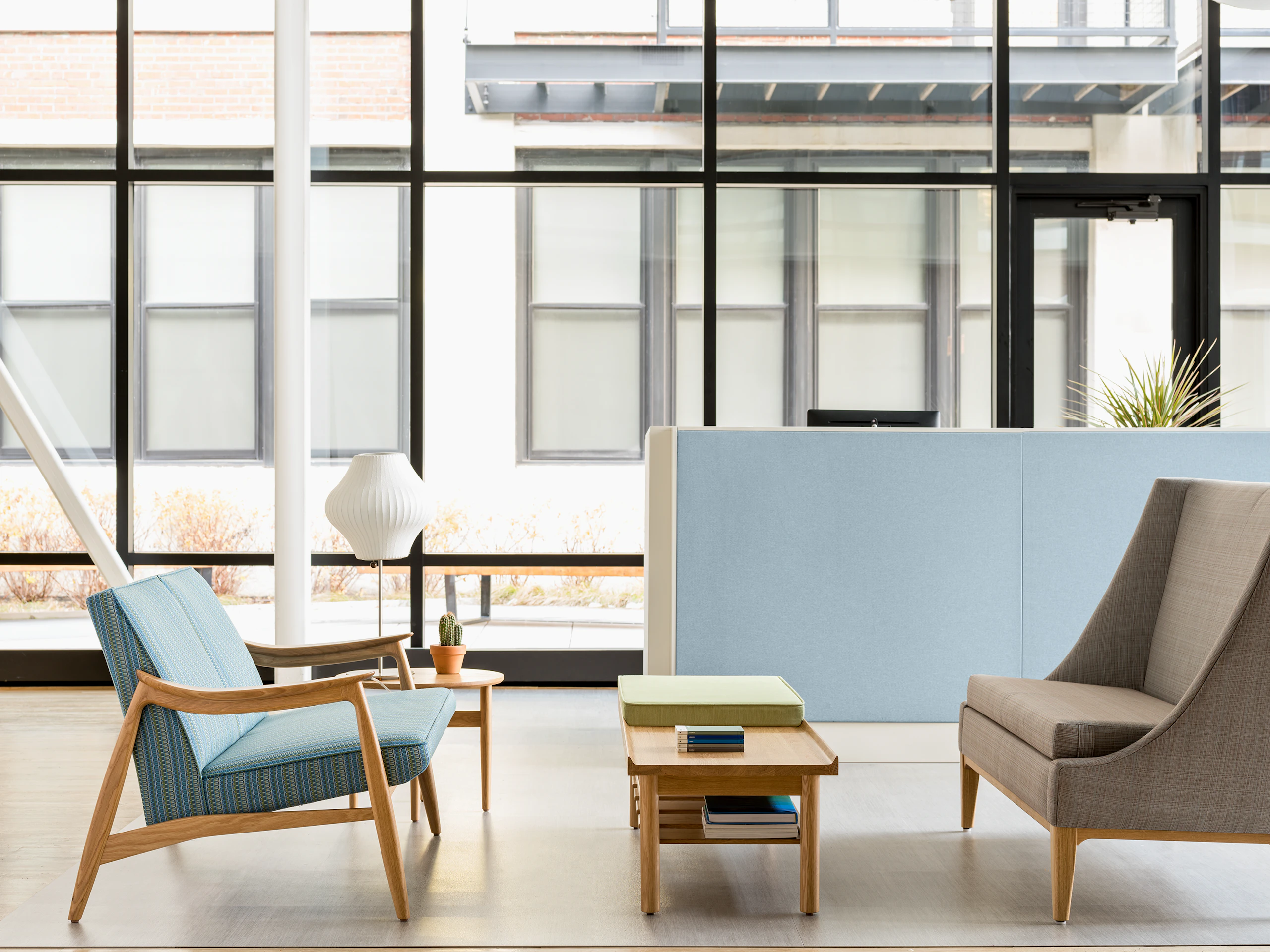 Waiting area with a Nemschoff Aspen Settee, a Nemschoff Hemlock Side Table, a Nemschoff Tamarack Table and Bench, a Nemschoff Iris Settee, and a Ethospace Nurses Station.