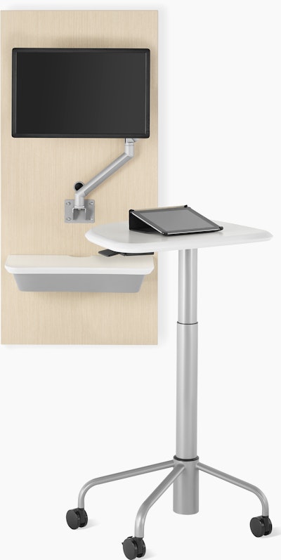 An Intent Solution technology support wall unit in an ash wood finish with an Intent Solution mobile, height-adjustable table.