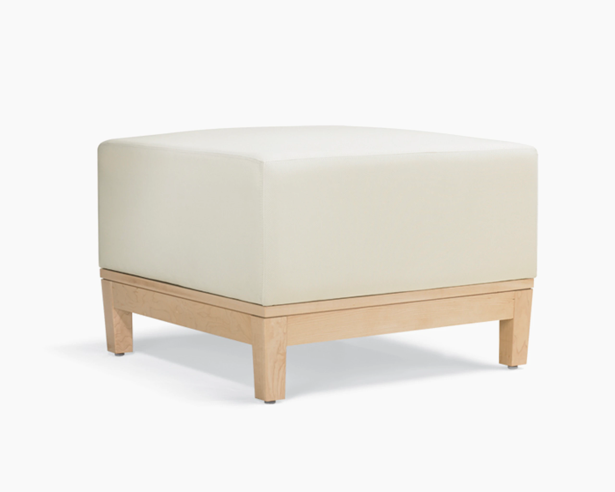 A three-quarter view of a short, ottoman-style Brava Platform Lounge Bench with maple base and white textile.