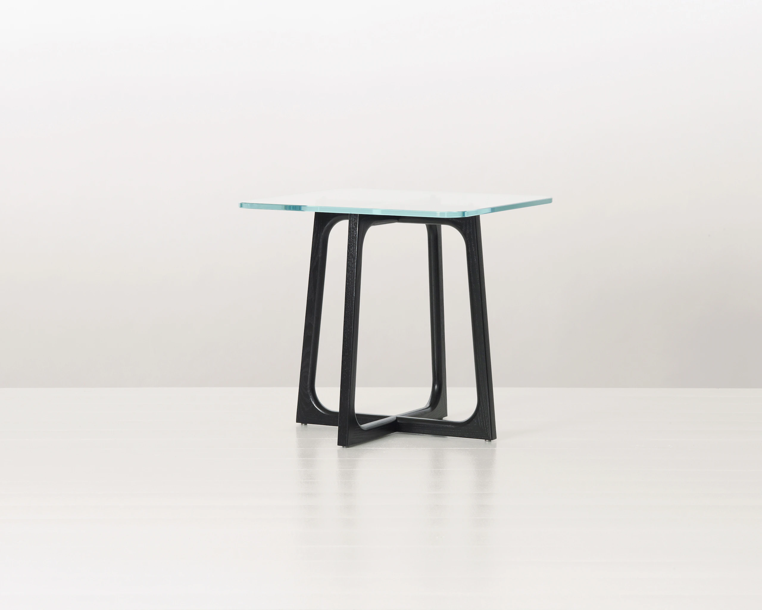 A square Loophole side table with a glass top and ebony-ash base.