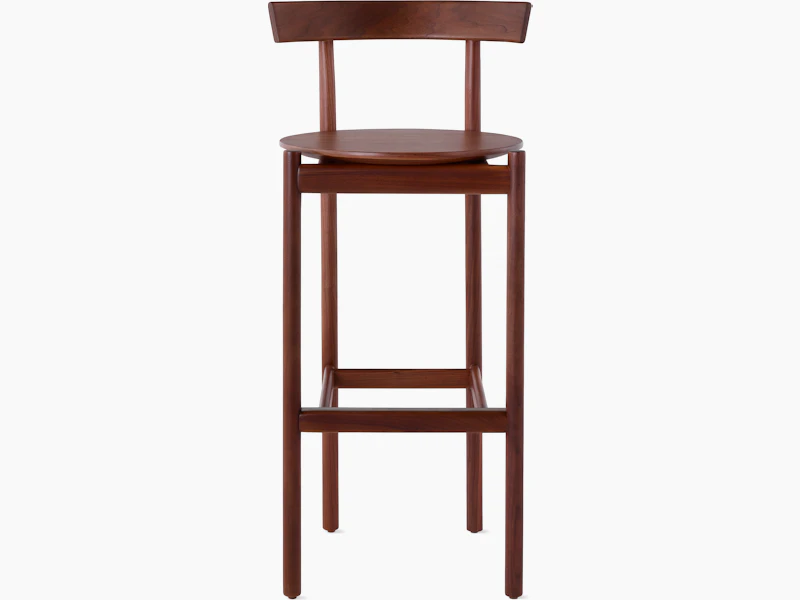 A walnut bar-height Comma Stool, viewed from the front.