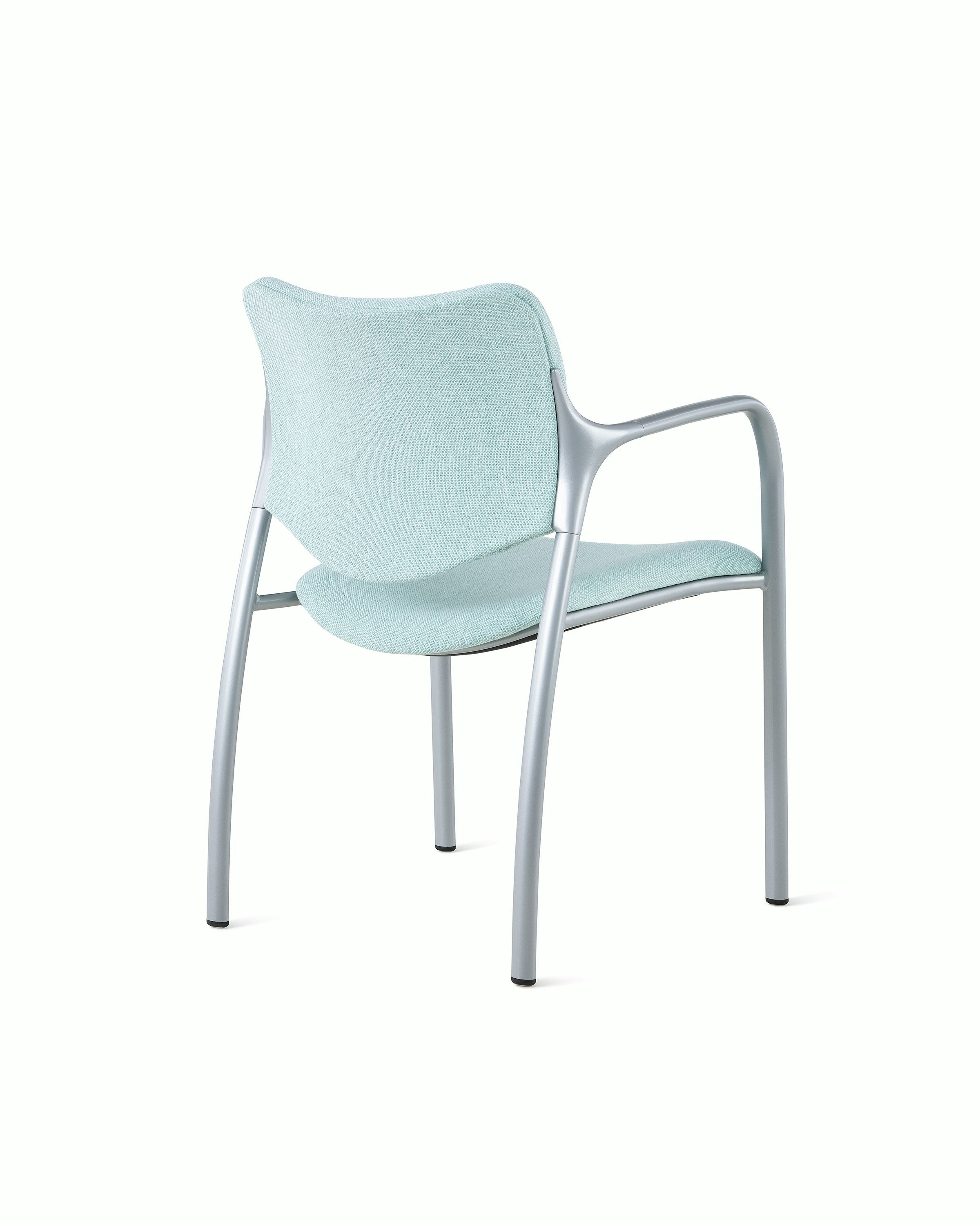 An Aside Chair with light green upholstered seat and back, viewed from the back at an angle.