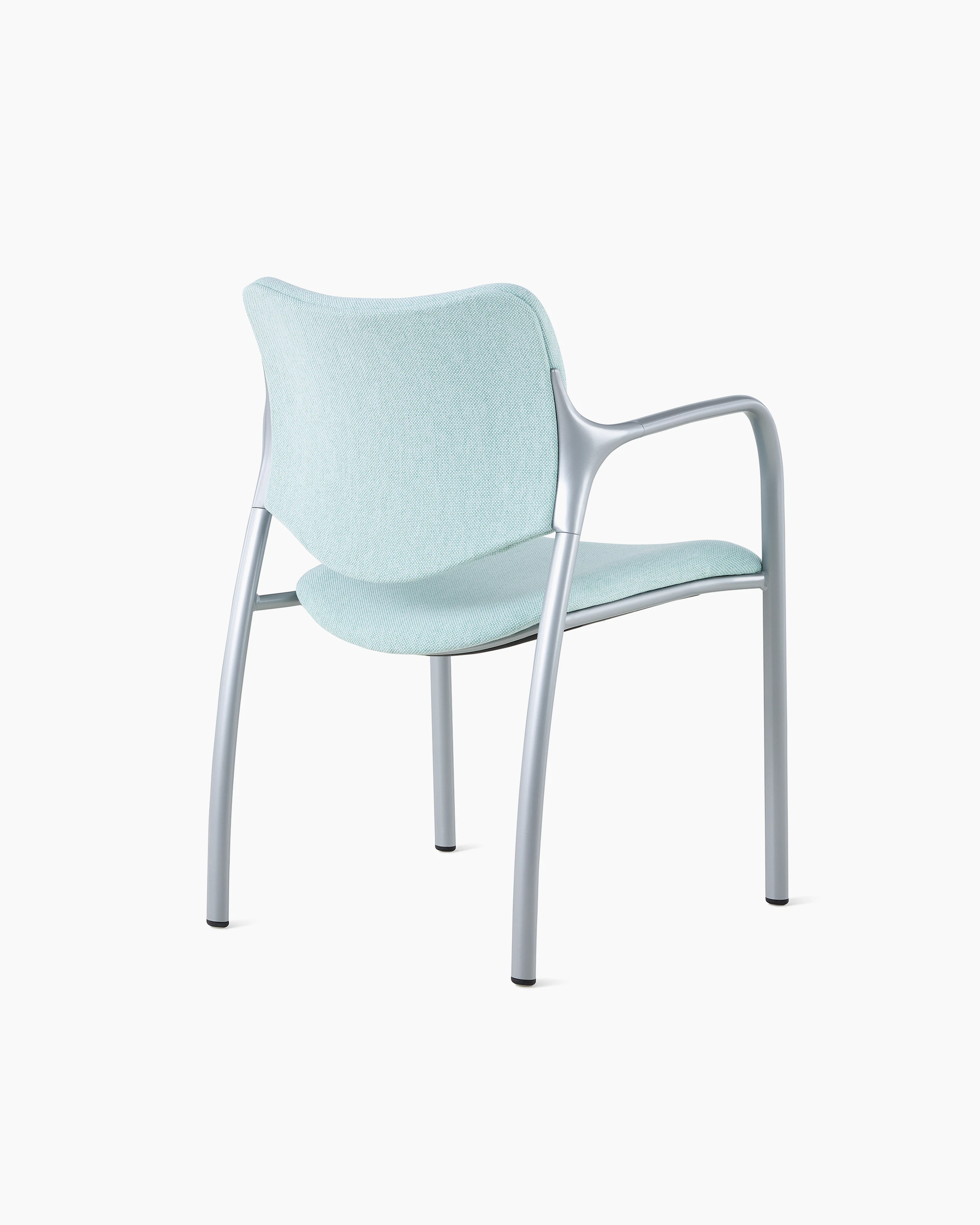 An Aside Chair with light green upholstered seat and back, viewed from the back at an angle.