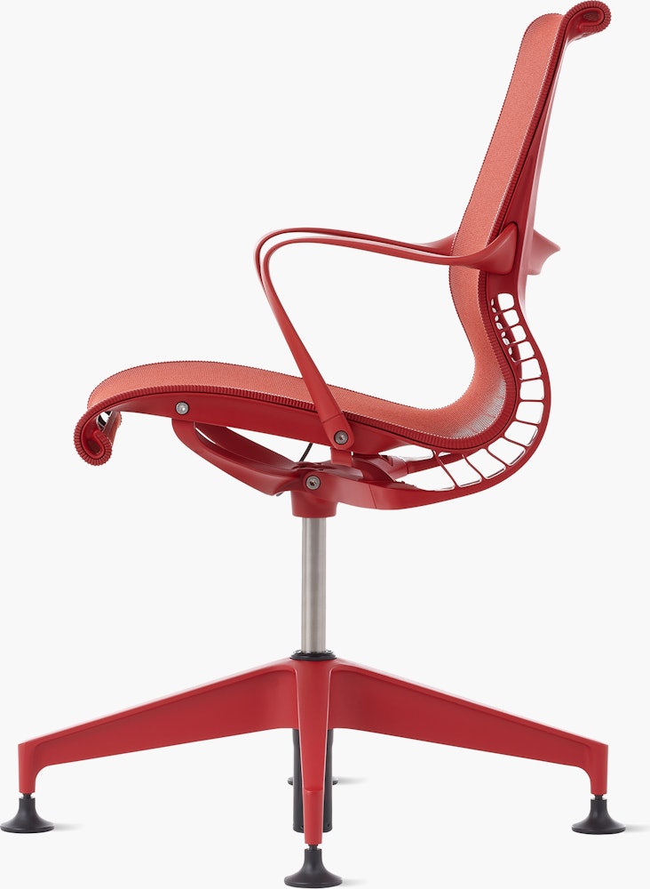 Side  view of a Setu side chair with fixed arms in red.