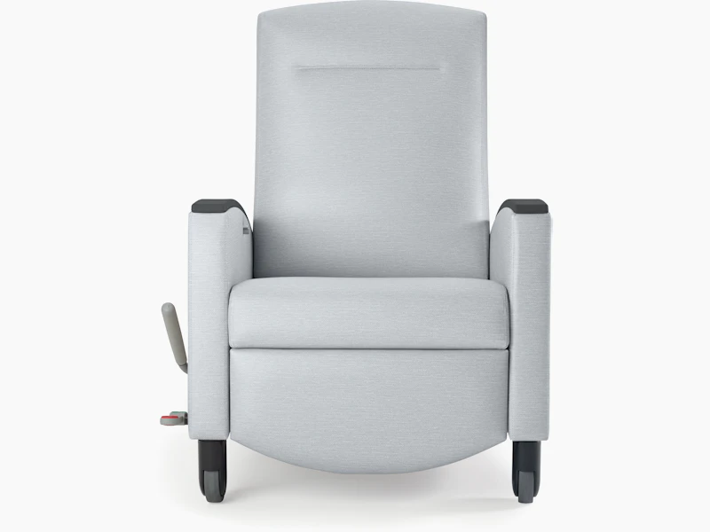 Nemschoff Sahara Recliner in a light gray upholstery and black arm caps and casters on white sweep, viewed from the front.