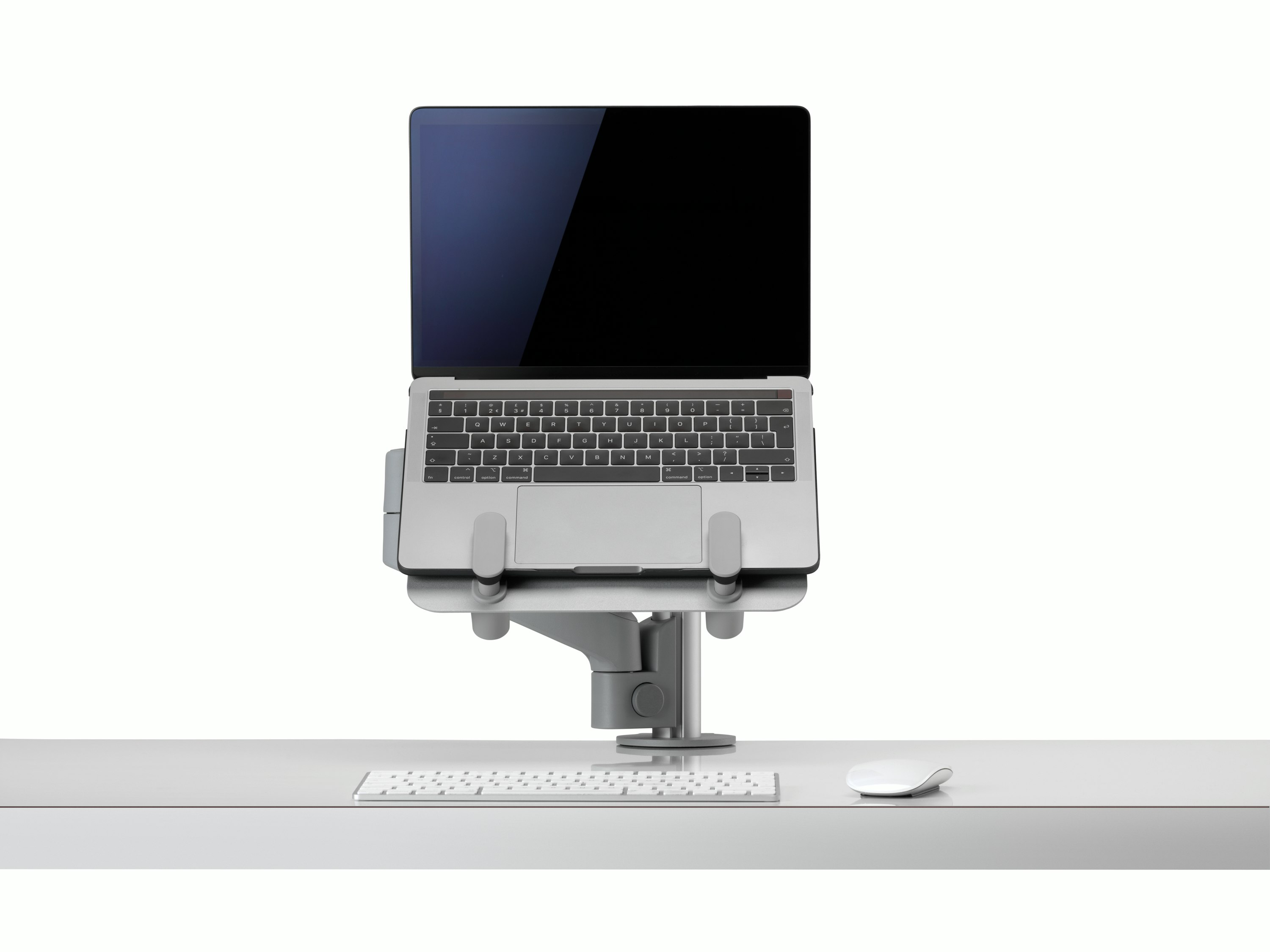 An open laptop raised from a desk and supported by a grey Lima Laptop Mount and Lima Monitor Arm.