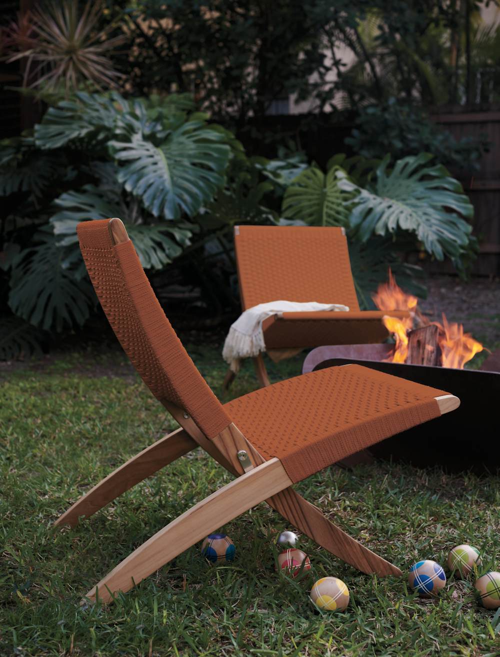 Cuba Outdoor Lounge Chair with Plodes Petal Fire pit in an outdoor setting