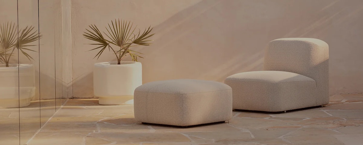 Muse Outdoor Armless Chair and Muse Outdoor Ottoman in an outdoor patio setting