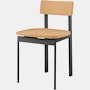 A cork Betwixt Chair with a black frame.