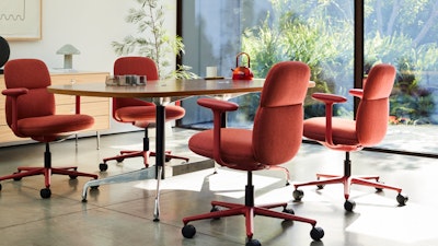 Four Asari chairs by Herman Miller in deep red surround a table in a room next to a sunny window.