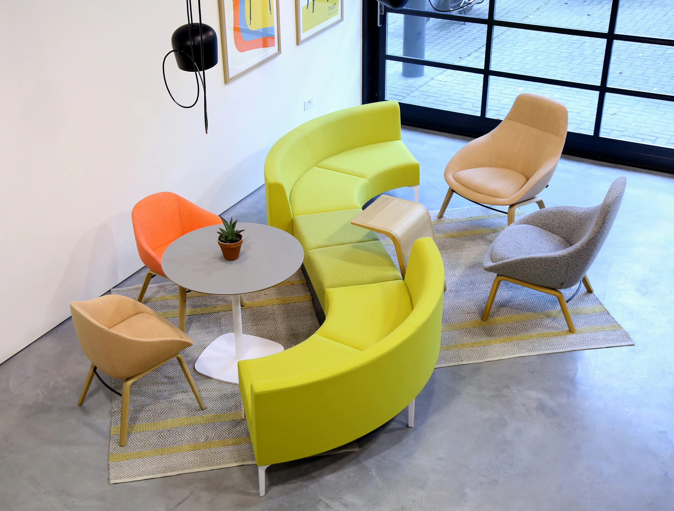 A green Symbol Bench joining two green 90 degree Symbol Modular Seating pieces.