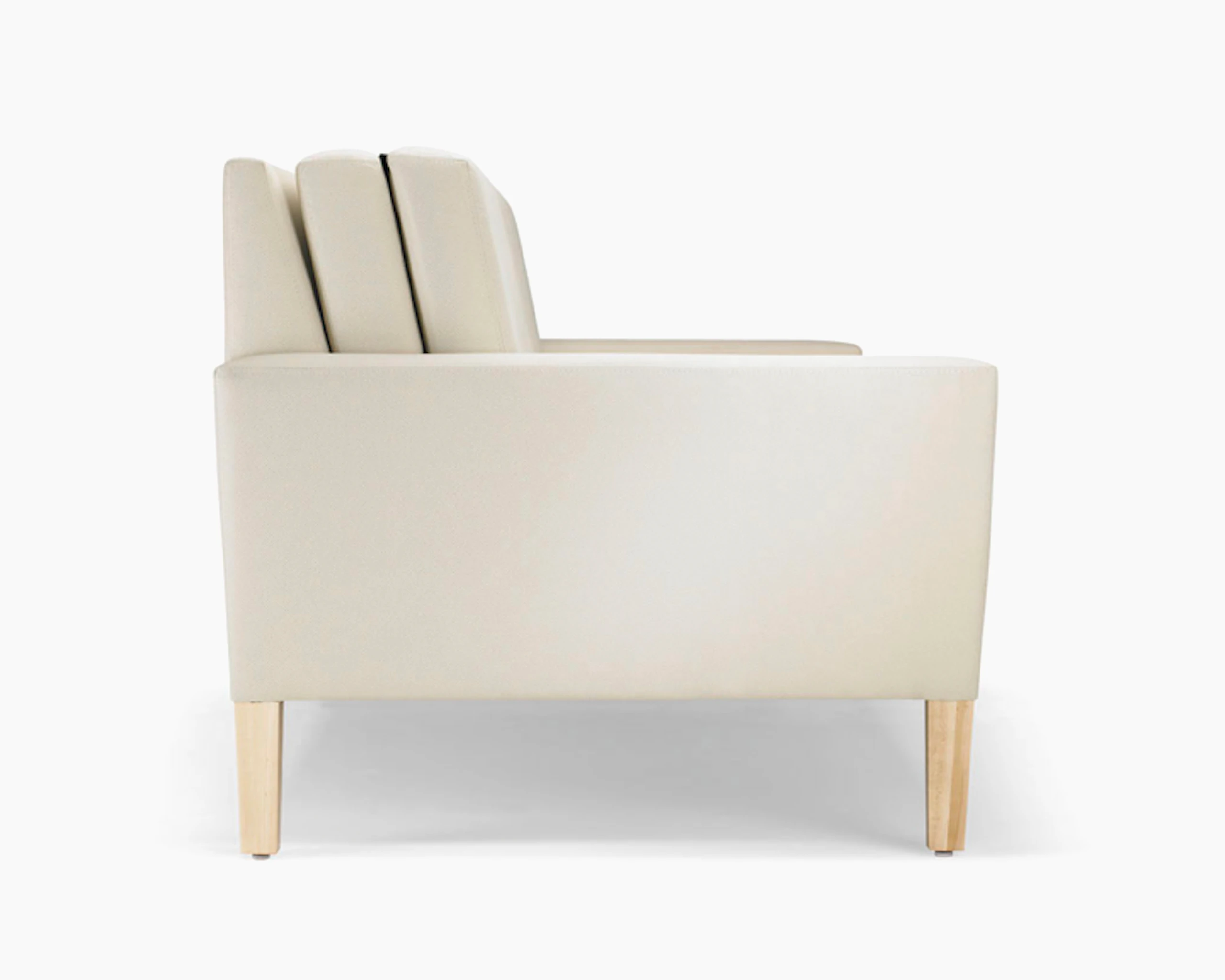 A side view of a Brava Flop Sofa in white textile with maple legs.