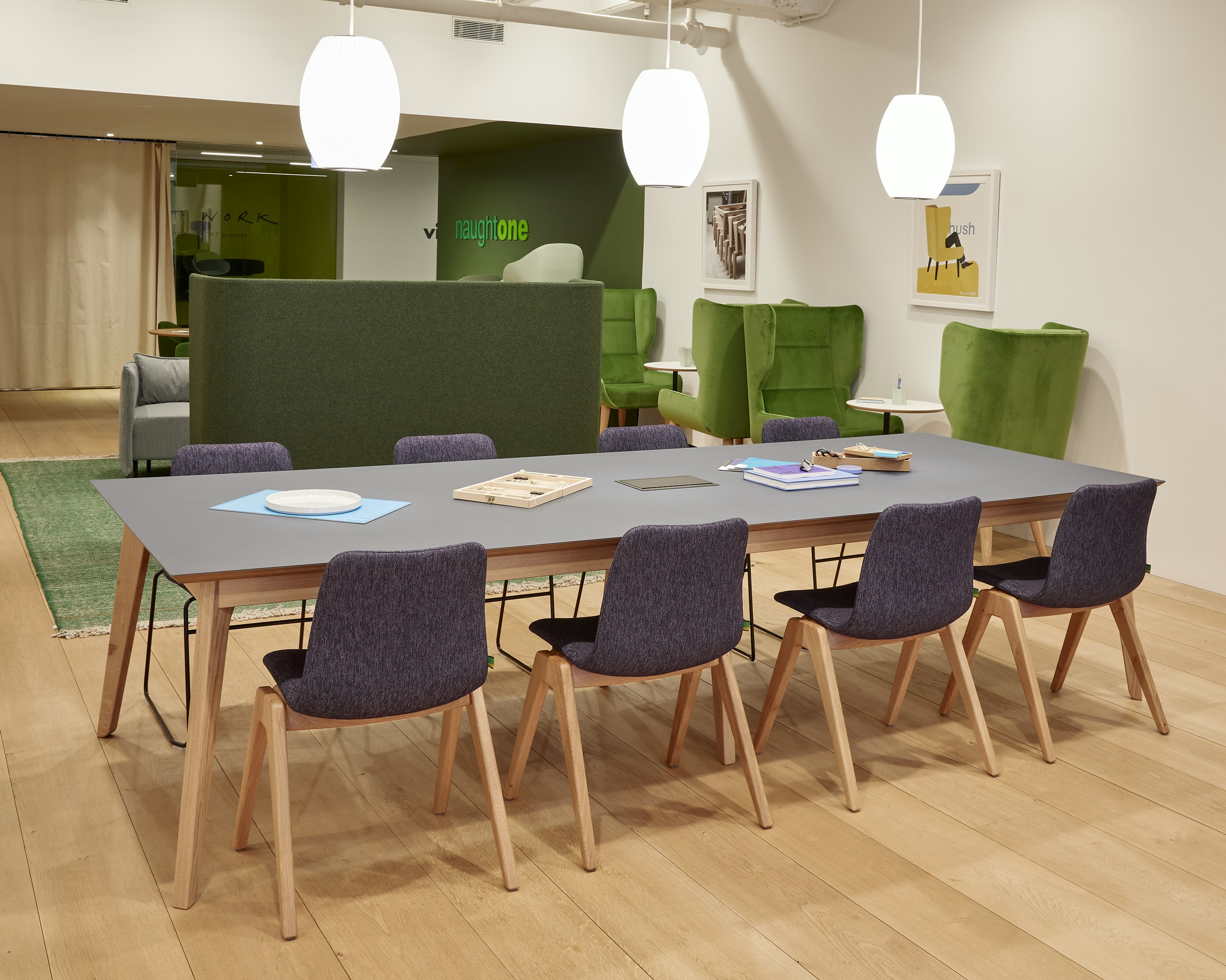 Eight upholstered Viv Wood Chairs with solid oak bases, around a large Dalby table.