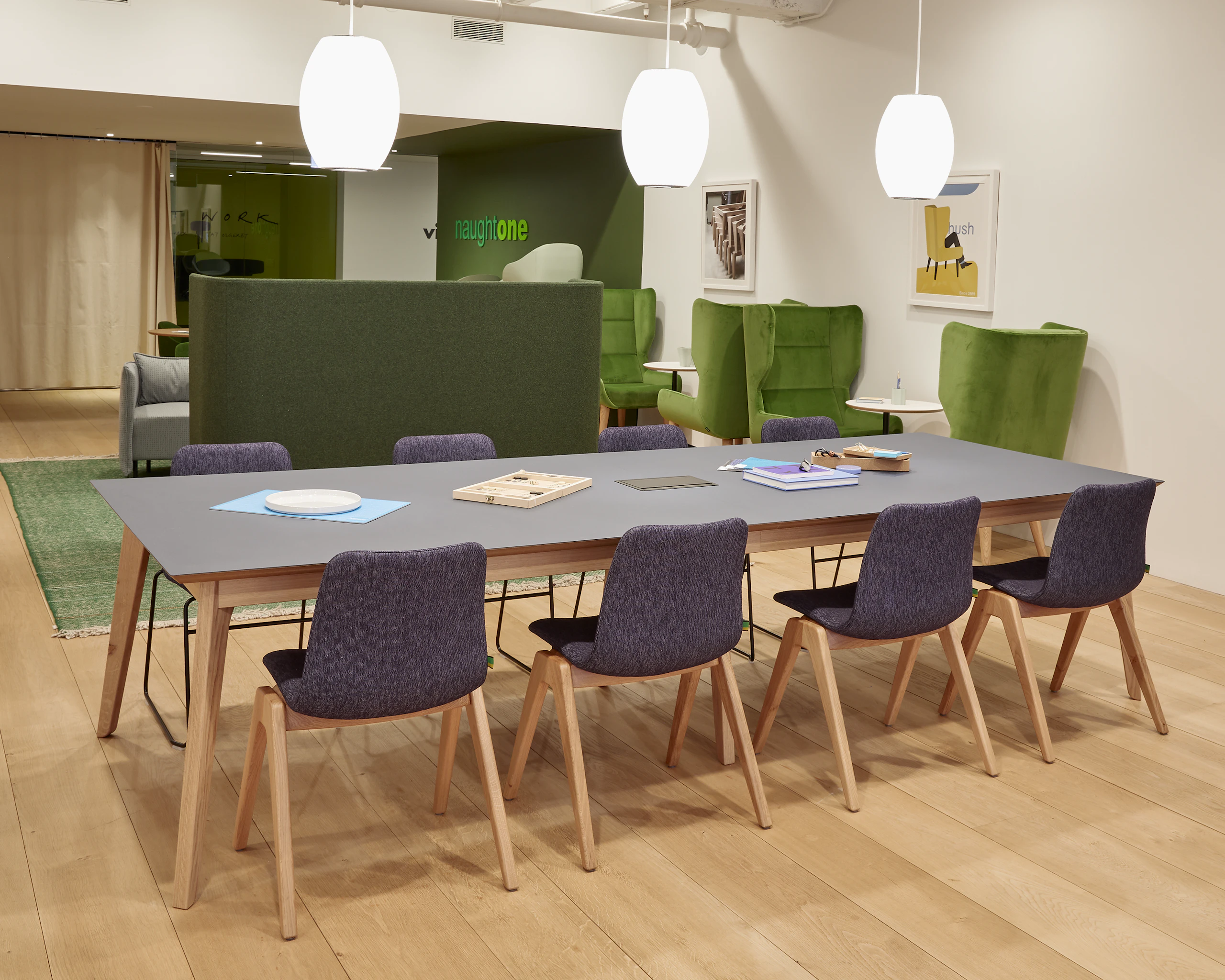 Eight upholstered Viv Wood Chairs with solid oak bases, around a large Dalby table.