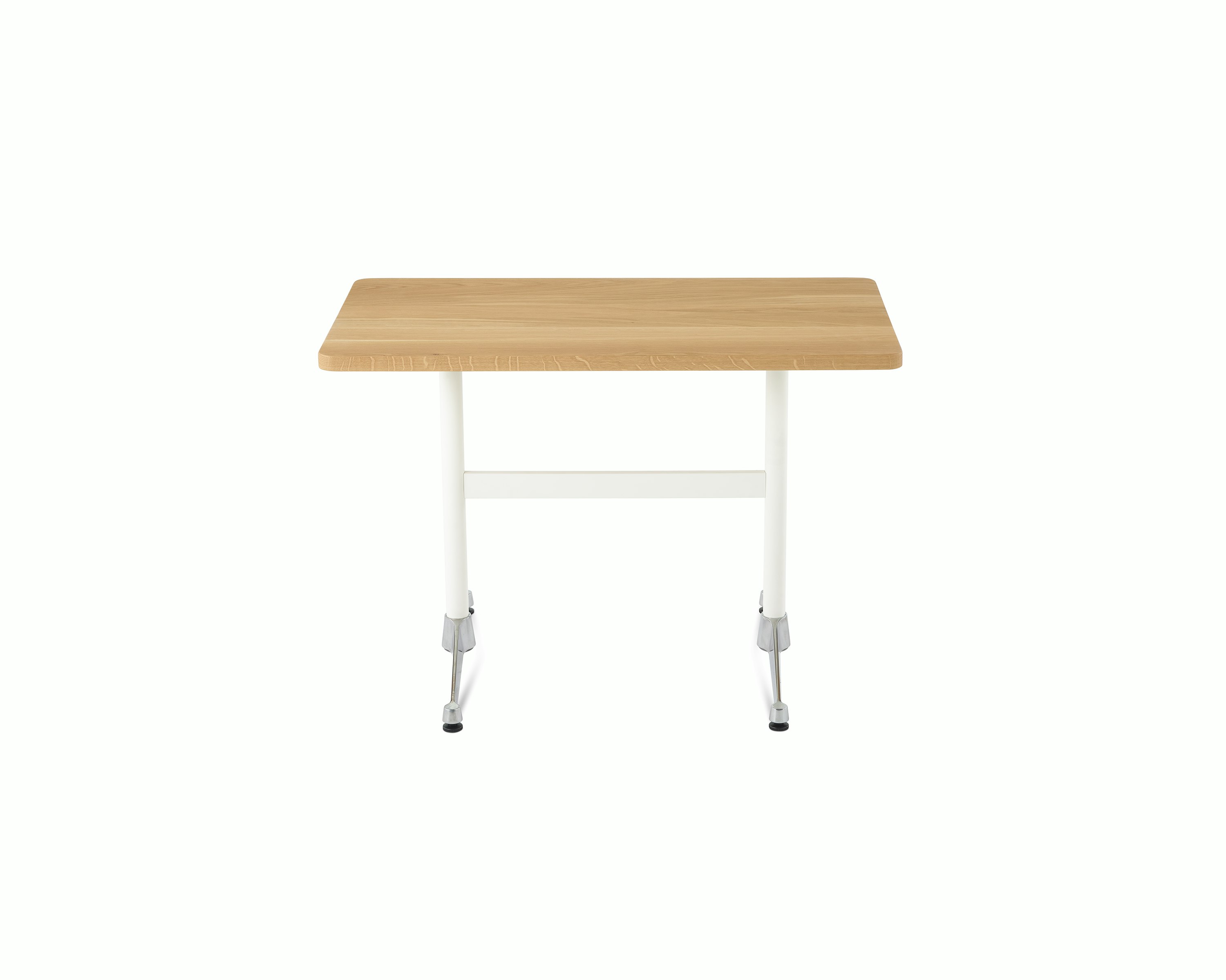An Eames T-Leg Table configured as a desk, with an oak top, white legs, and chrome feet.
