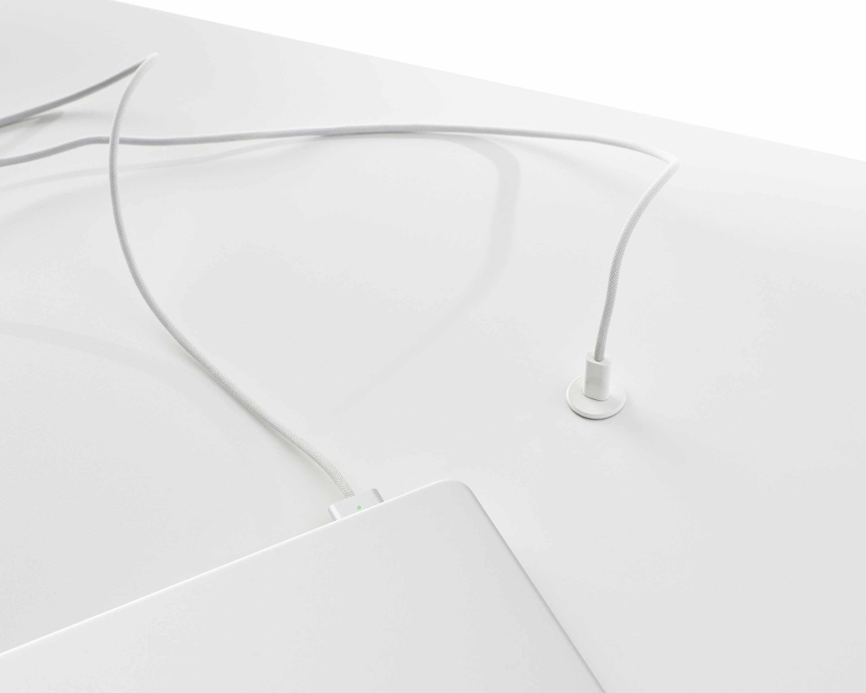 Surface-integrated single port USB-C power solution shown in white charging a laptop.