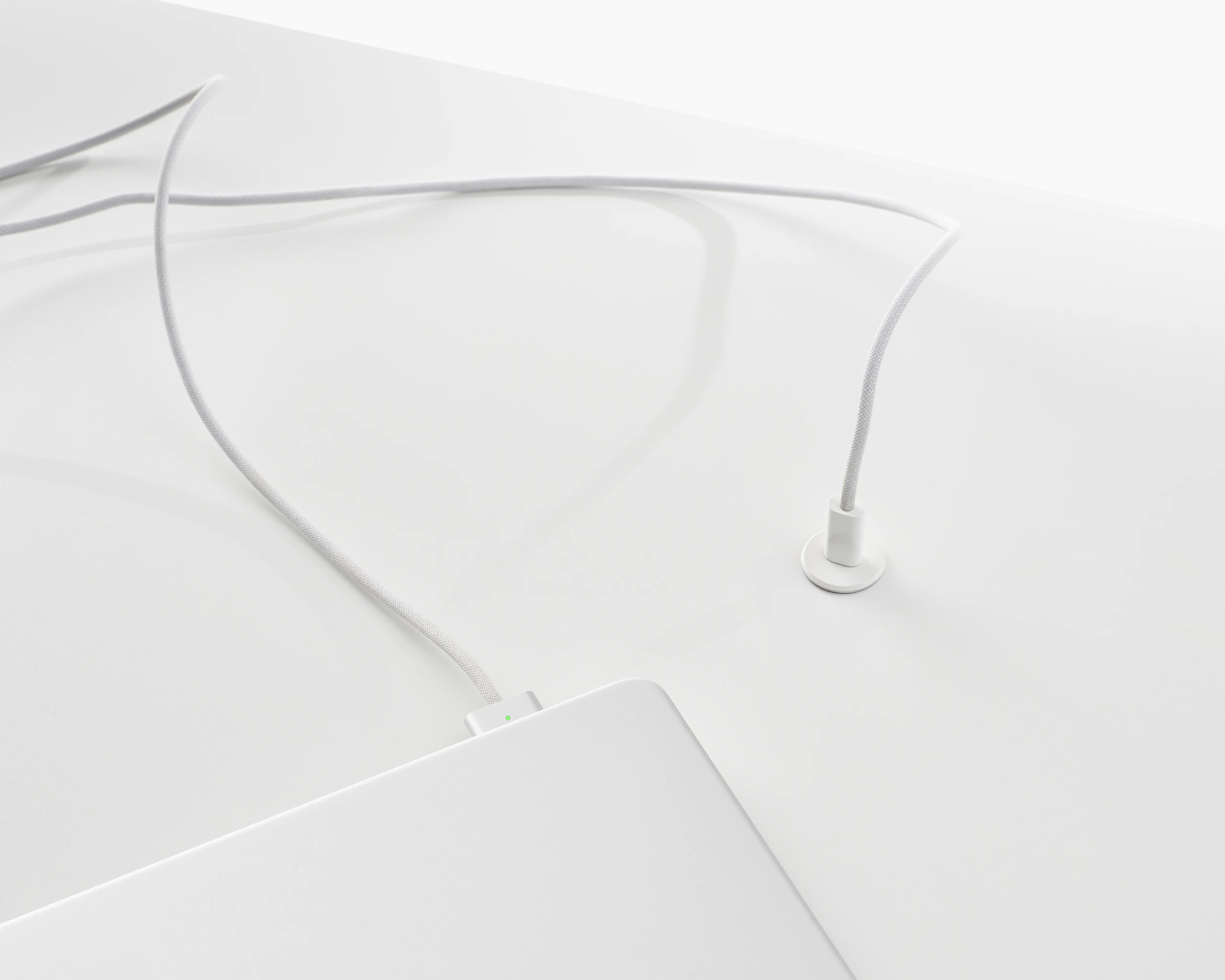 Surface-integrated single port USB-C power solution shown in white charging a laptop.
