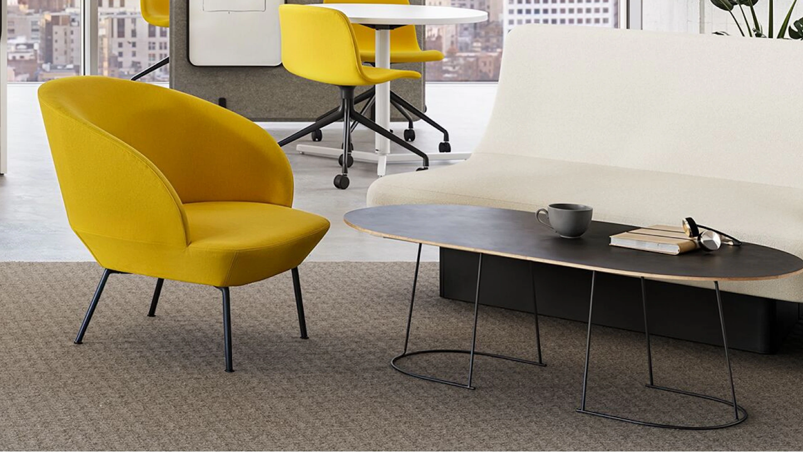 A yellow Muuto Oslo Lounge Chair and white NaughtOne Rhyme Seating System in a team neighborhood setting designed to facilitate connection and collaboration