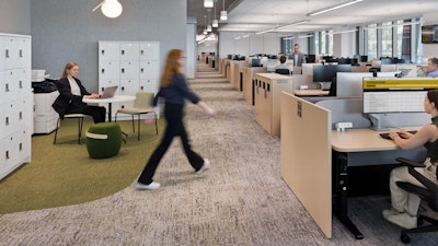 Several individuals working in the BlackRock offices in New York City furnished with assorted MillerKnoll products such as the Renew sit-to-stand tables