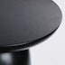 A close up view of the top surface of a Hew Side Table in a painted black finish.