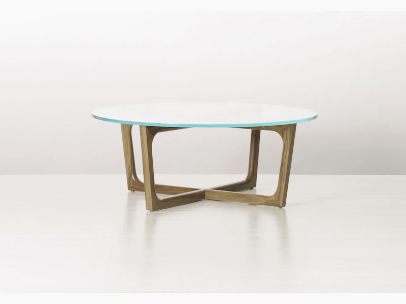A round Loophole coffee table with a glass top and a walnut base.