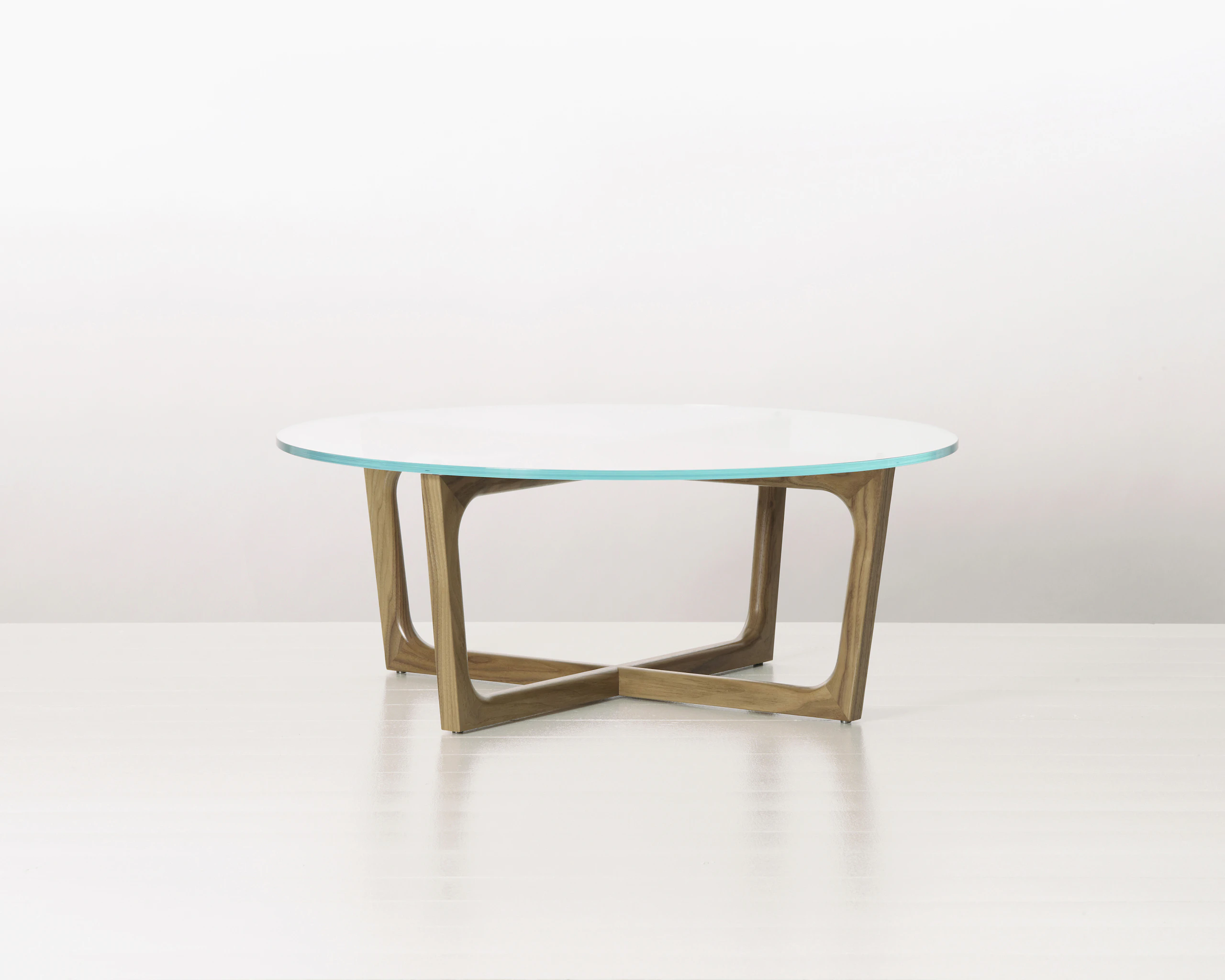 A round Loophole coffee table with a glass top and a walnut base.