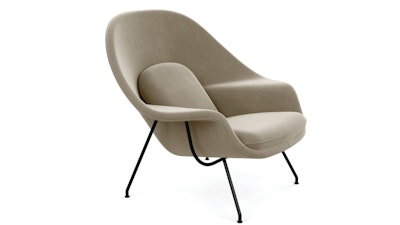 A side view of a beige Knoll Womb chair on a white background