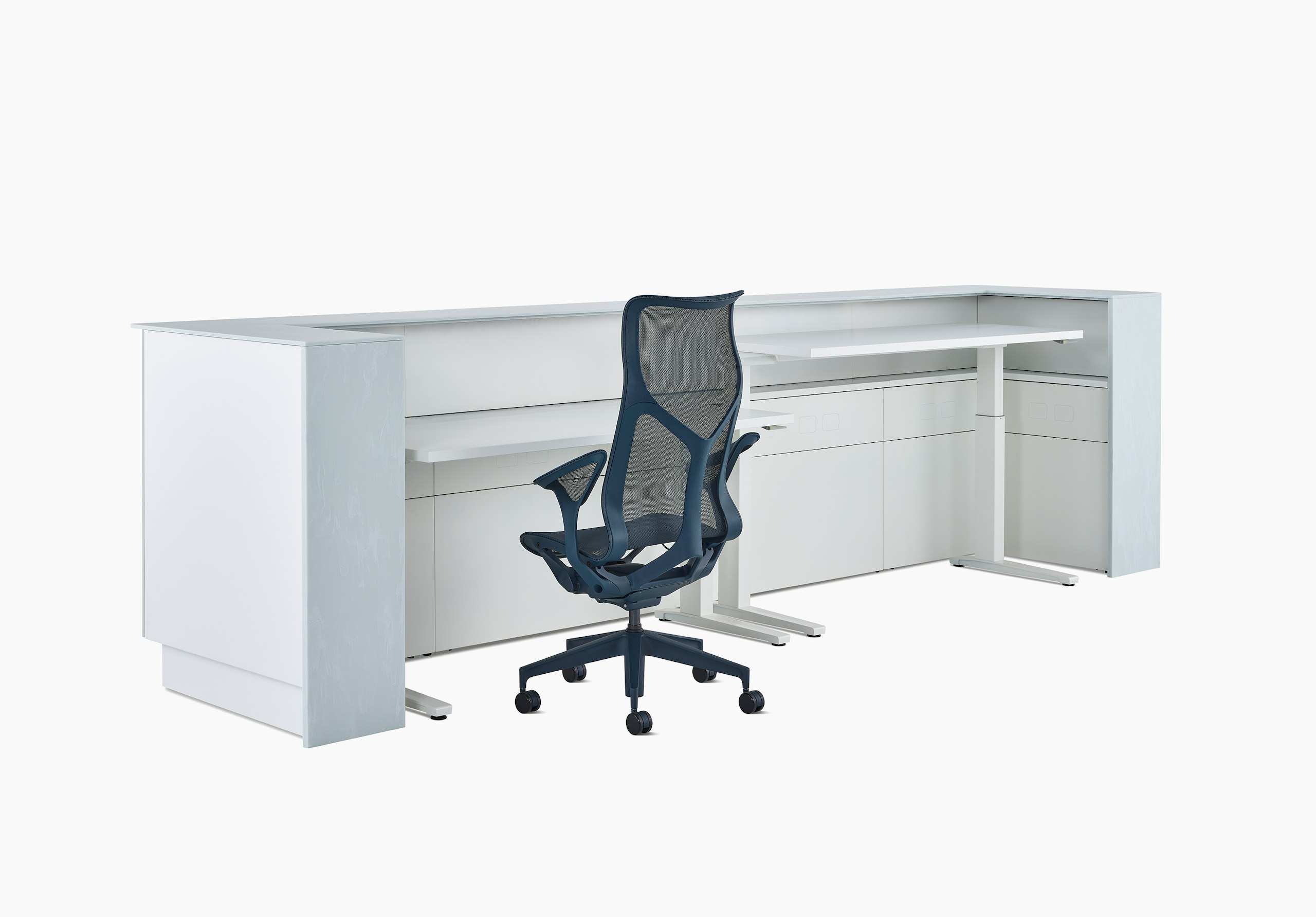 A Commend Nurses Station with two white Renew Sit-to-Stand Tables at differing heights and a Cosm chair tucked within its interior.