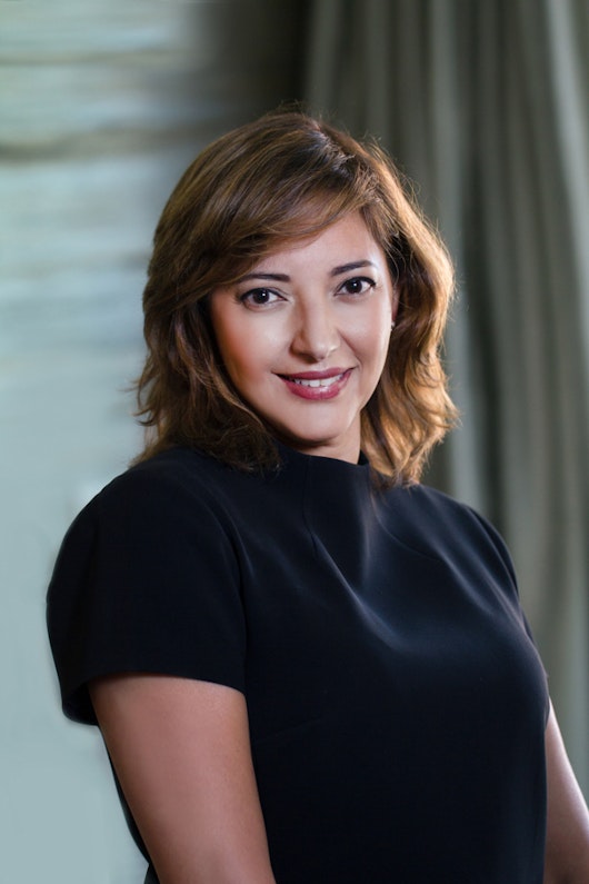 Tina Edmundson, a member of the Board of Directors of MillerKnoll, Inc., smiling wearing a dark blue top