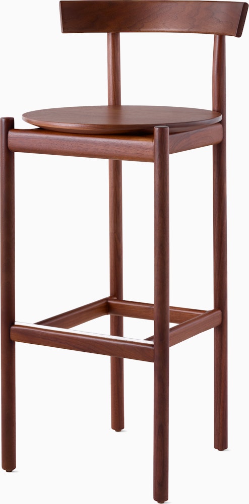 A walnut bar-height Comma Stool, viewed from the front at an angle.