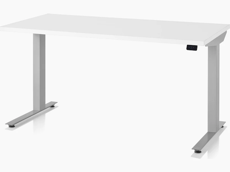 A three-quarter view of a white top, silver leg, Nevi Sit-to-Stand Table at a seated height.