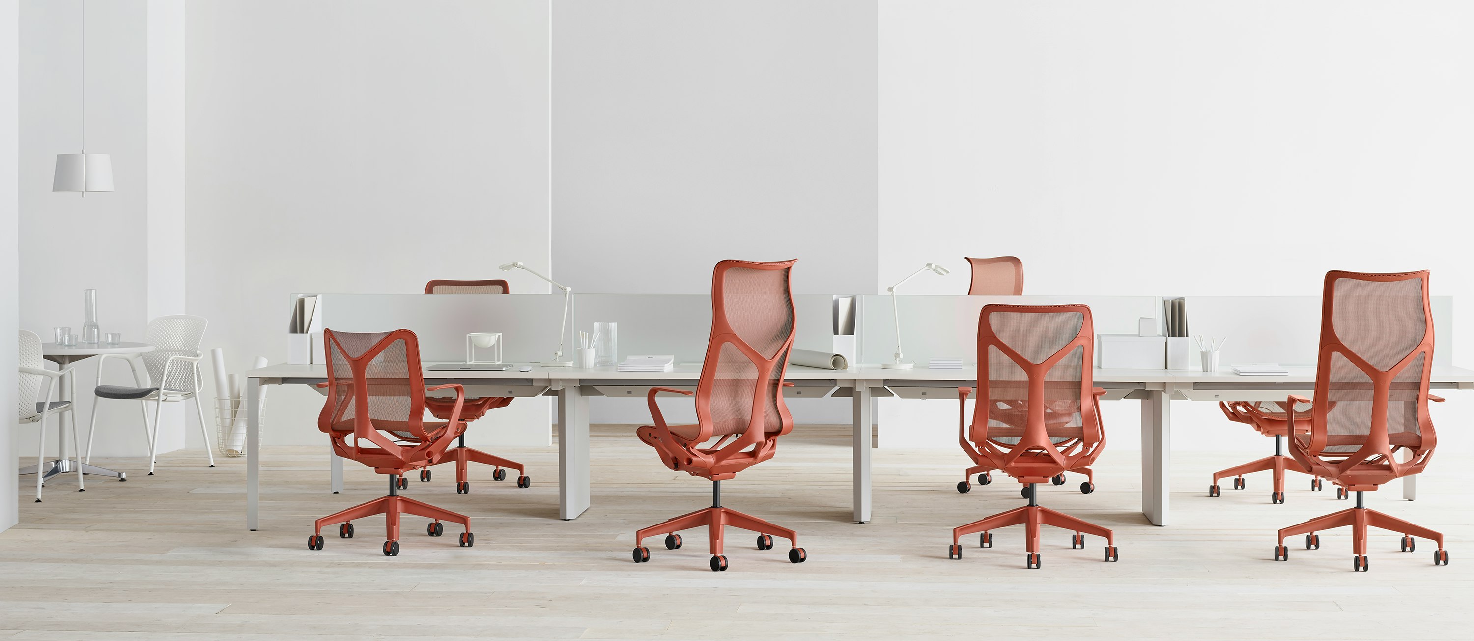Cosm chairs in red around a workstation.