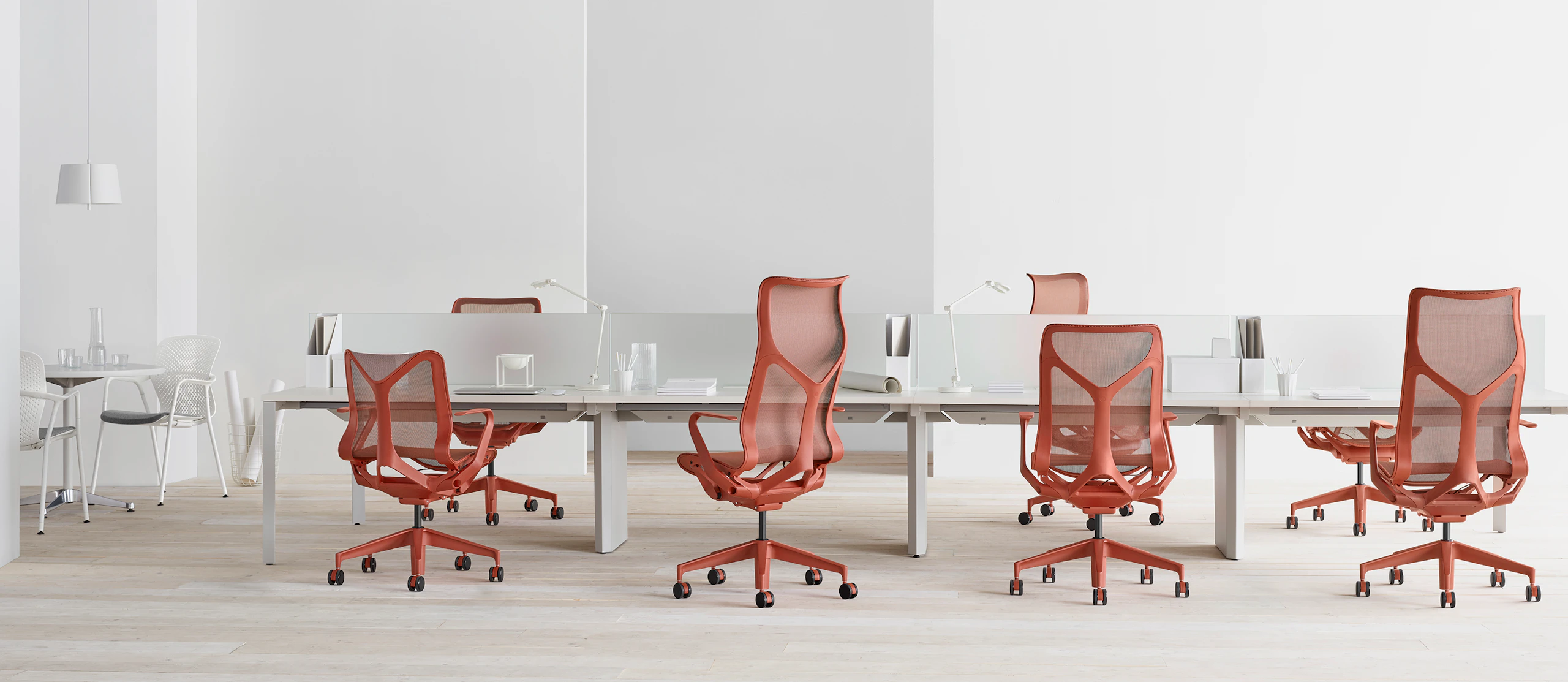 Cosm chairs in red around a workstation.