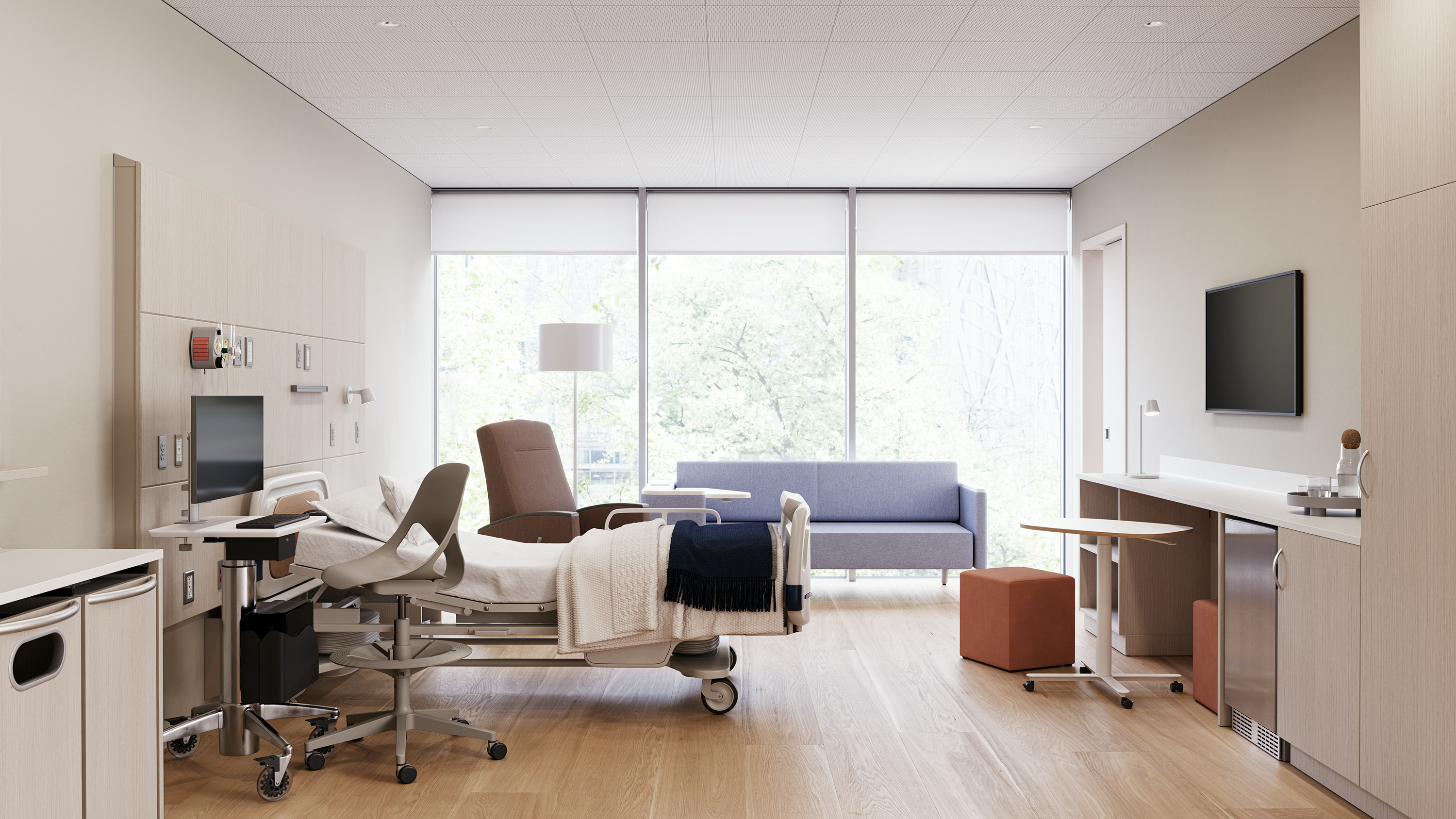 Patient room featuring headwall and footwall casework, a recliner, and sleeper sofa to accommodate families and guests.