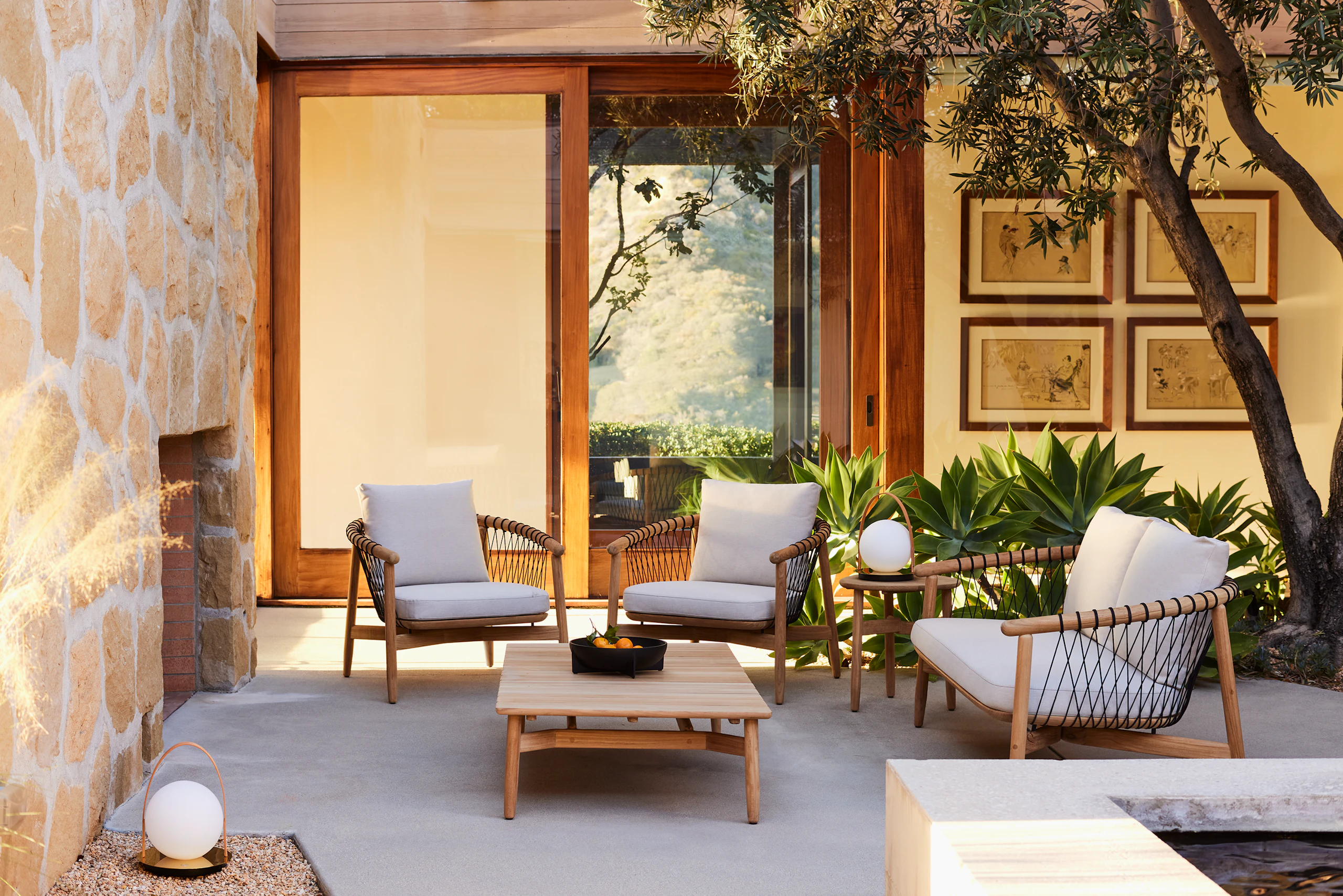 Crosshatch Outdoor Lounge Chairs, Settee and Occasional Tables in an environmental setting.