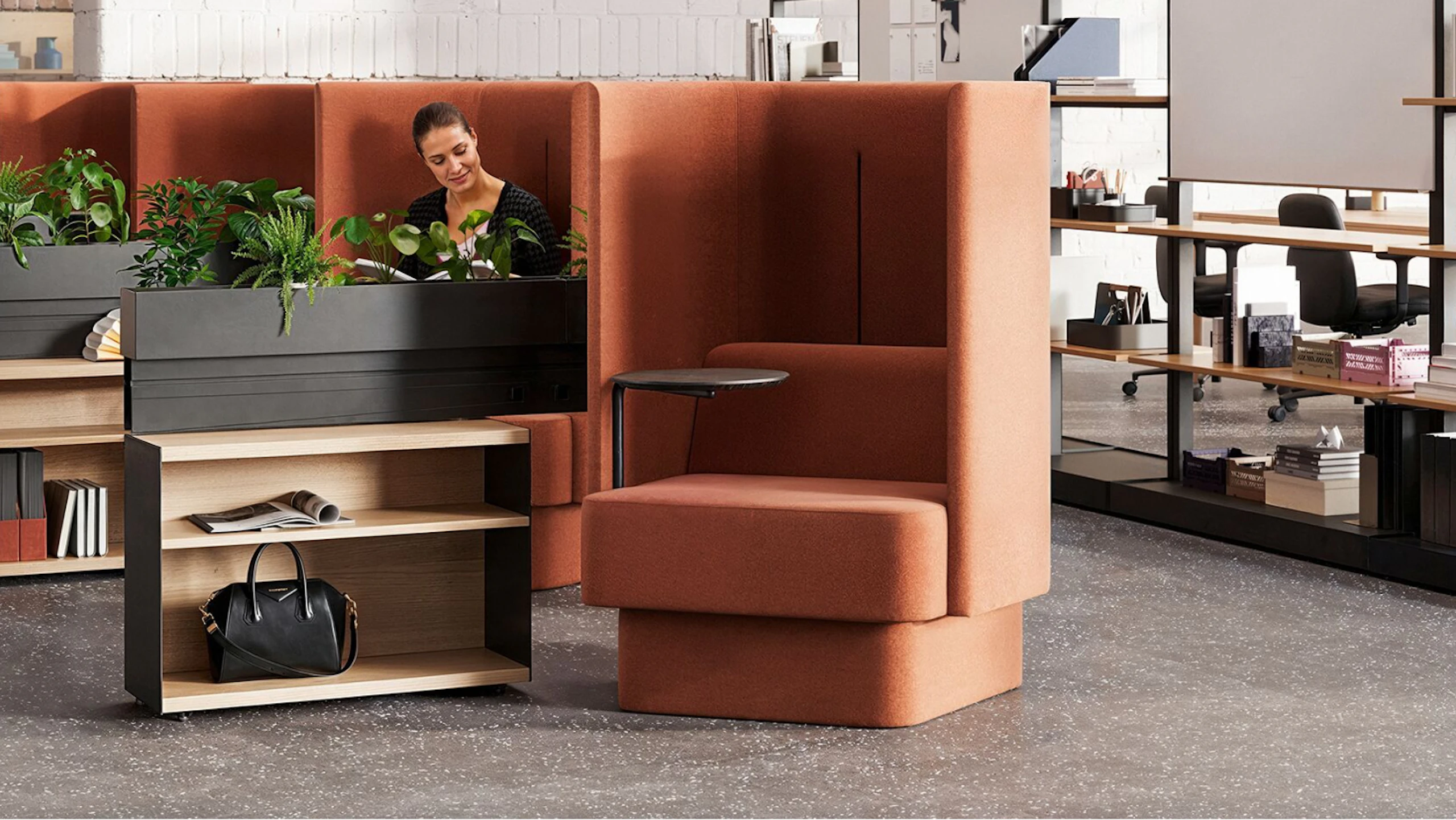 A bank of burnt-orange NaughtOne Pullman chairs next to Herman Miller OE1 Storage Trolleys in an individual study hall setting designed to cultivate an area of focus and wellbeing