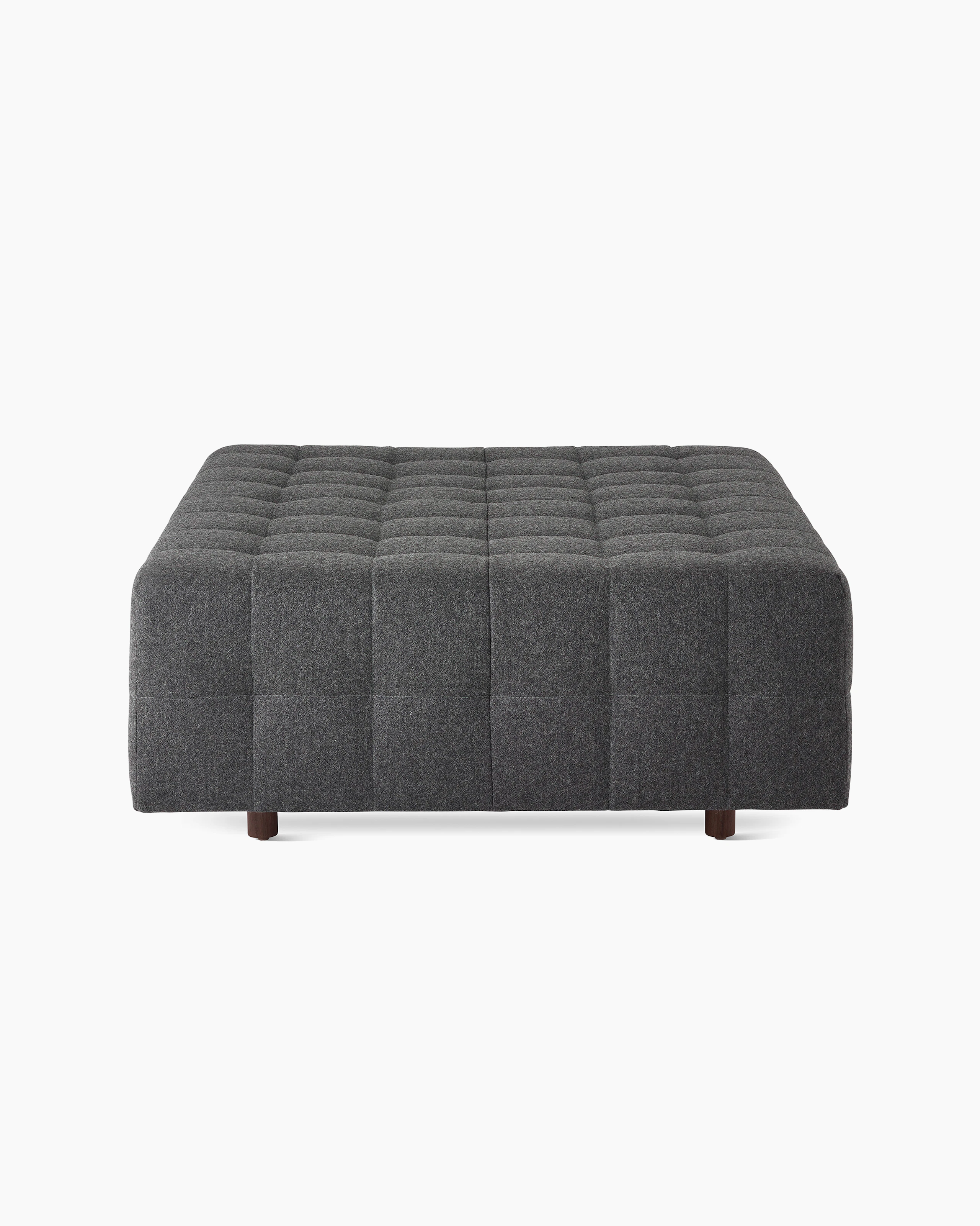 A Rapport ottoman upholstered in a dark grey fabric.