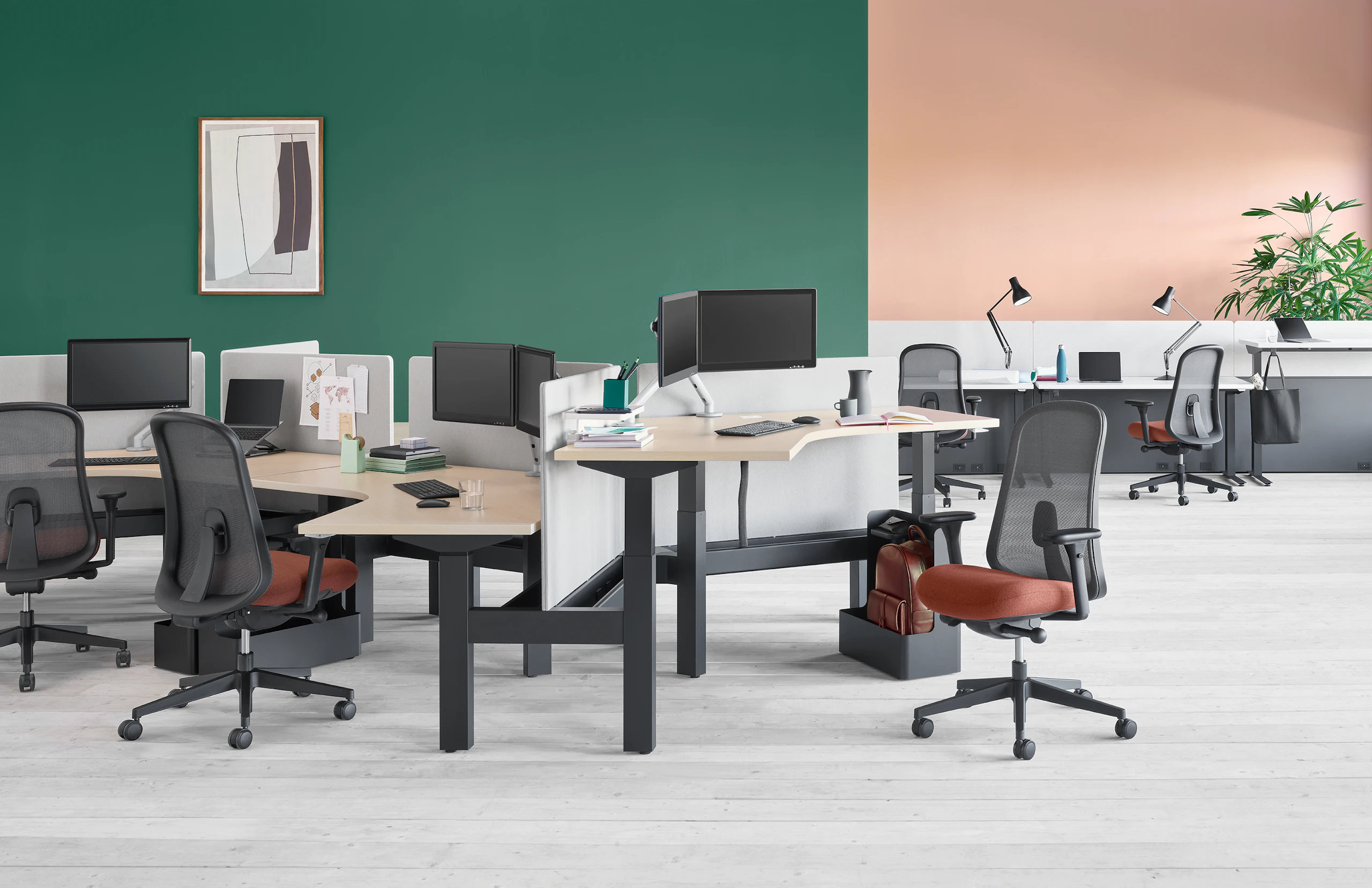 Standing desk system, Nevi Link, with 120-degree work surfaces in the foreground and Nevi Sit-to-Stand Tables with Canvas Channel in the background.