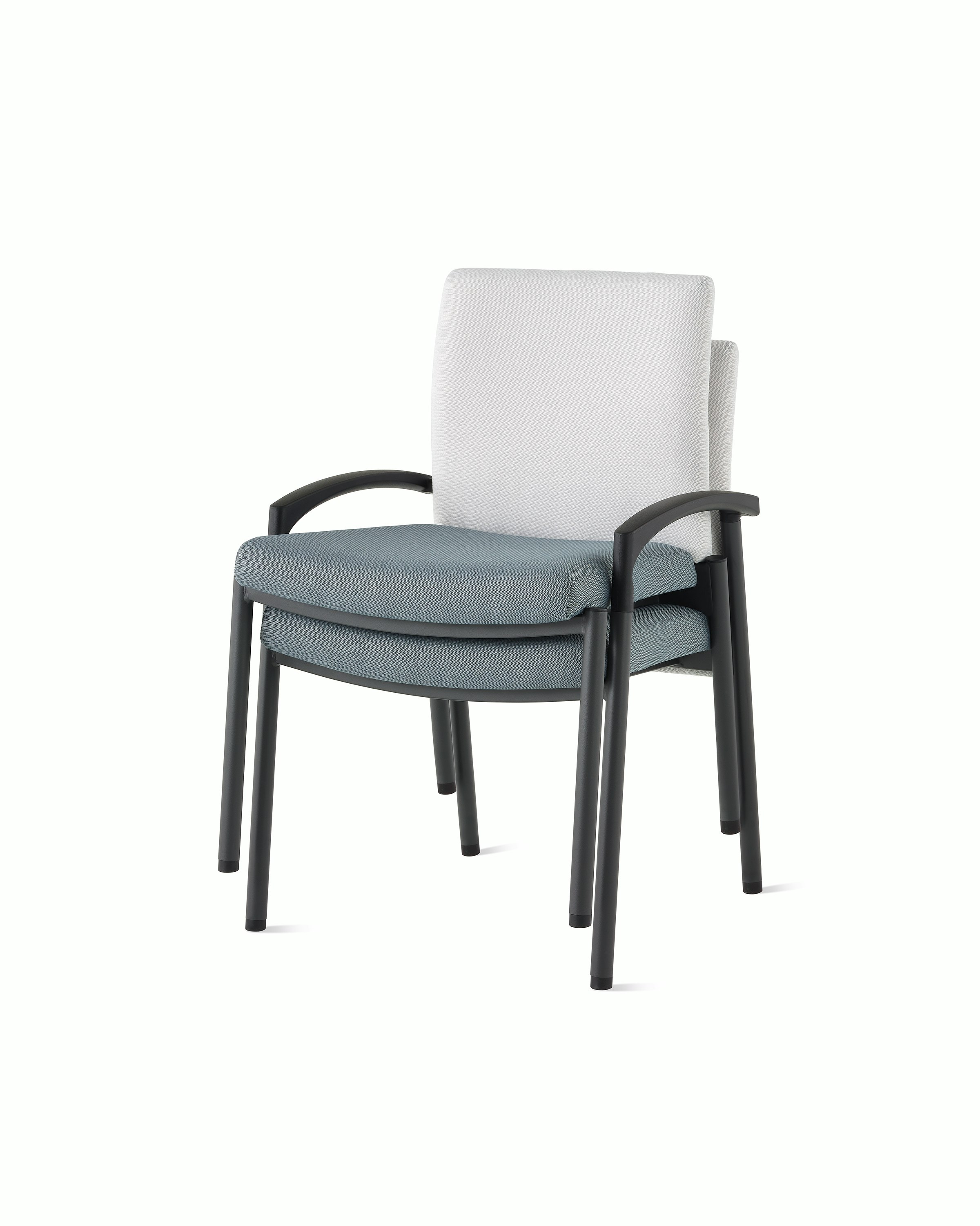 Three-quarter, front view of two Valor stacking chairs without arms stacked, with a white back upholstery and blue seat upholstery and black frame on white sweep.