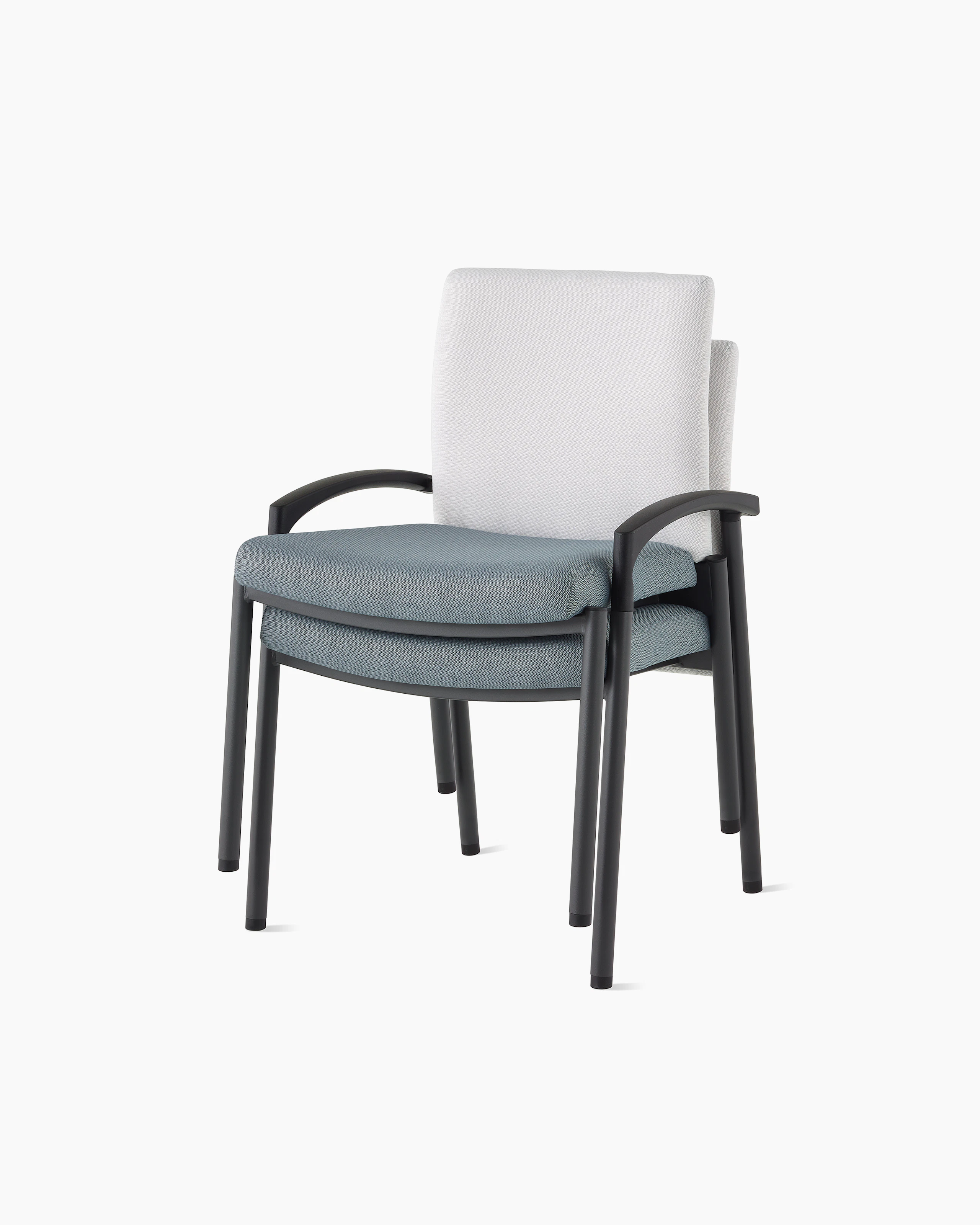 Three-quarter, front view of two Valor stacking chairs without arms stacked, with a white back upholstery and blue seat upholstery and black frame on white sweep.