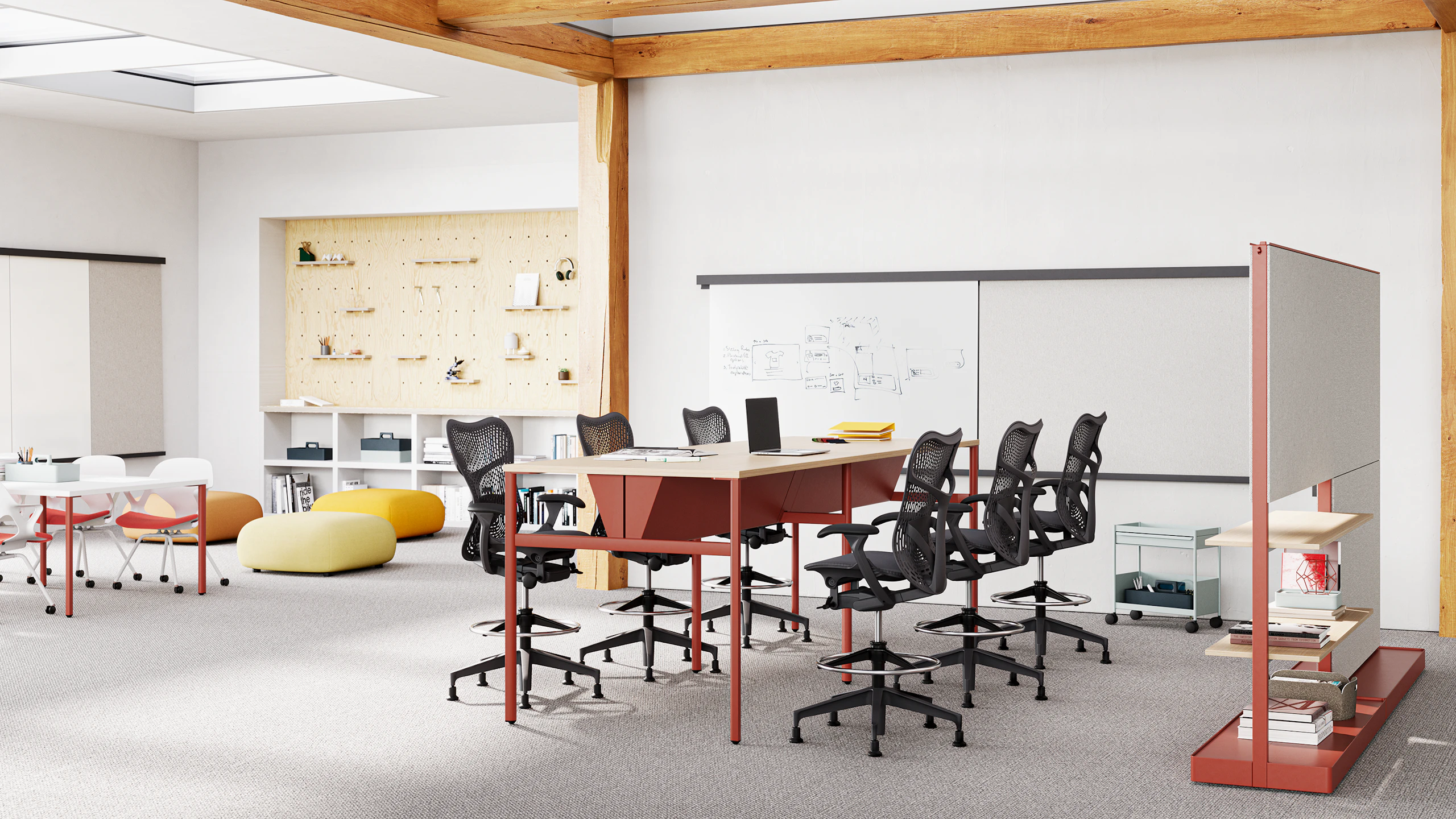 Six Mirra 2 stools in graphite surround an OE1 Communal table in Canyon in a workshop setting with OE1 boards and an Agile Wall. In the back of the space is another table surrounded wtth Zeph chairs.