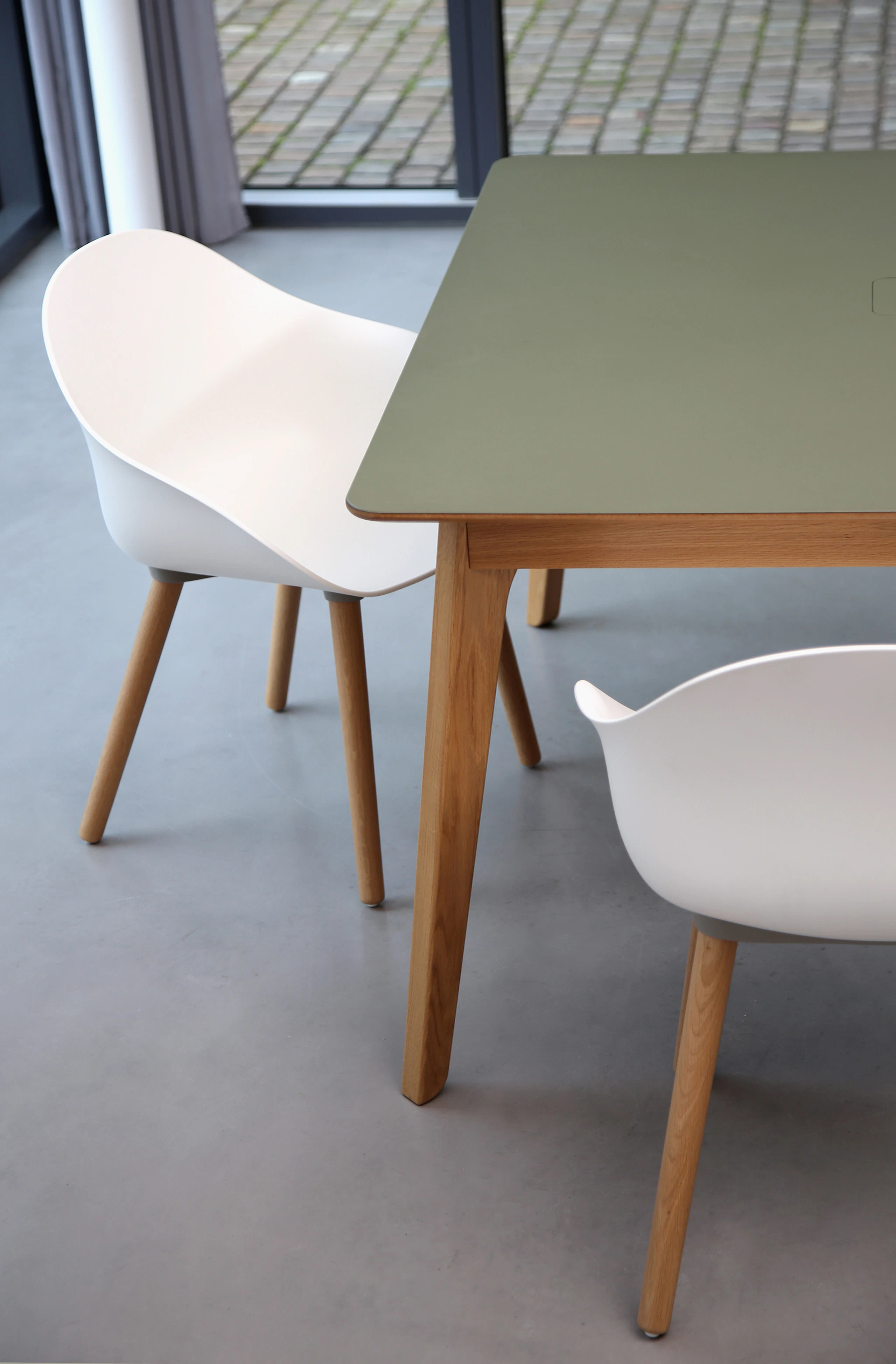 Two white Ruby Side Chairs on oak dowel bases with a table.