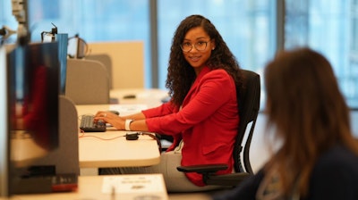 Two individuals working while seated at Renew sit-to-stand tables and Canvas Channel workstations