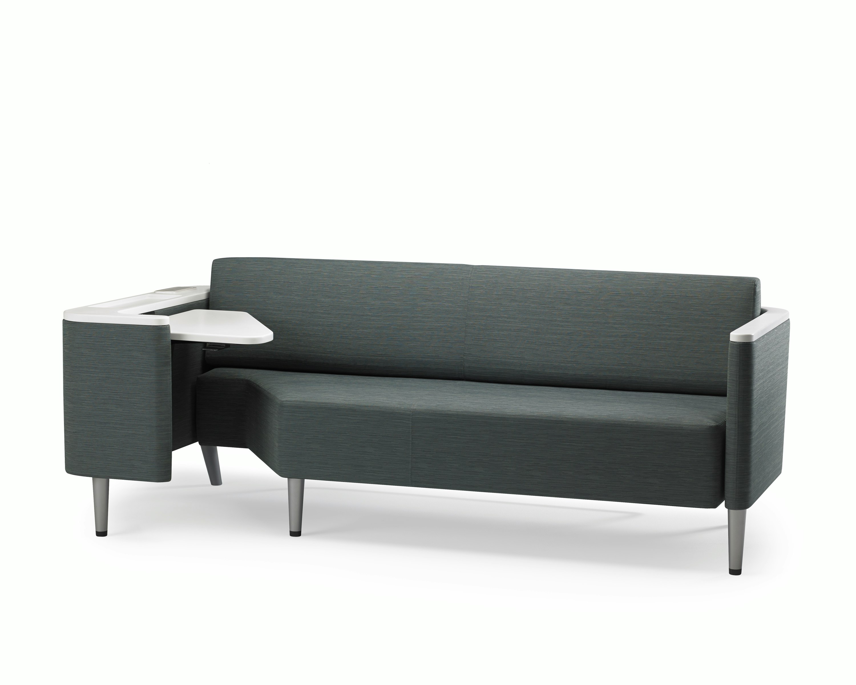 A Palisade Flop sofa in dark grey textile with white solid surface arms caps and white adjustable table with Durawrap top.