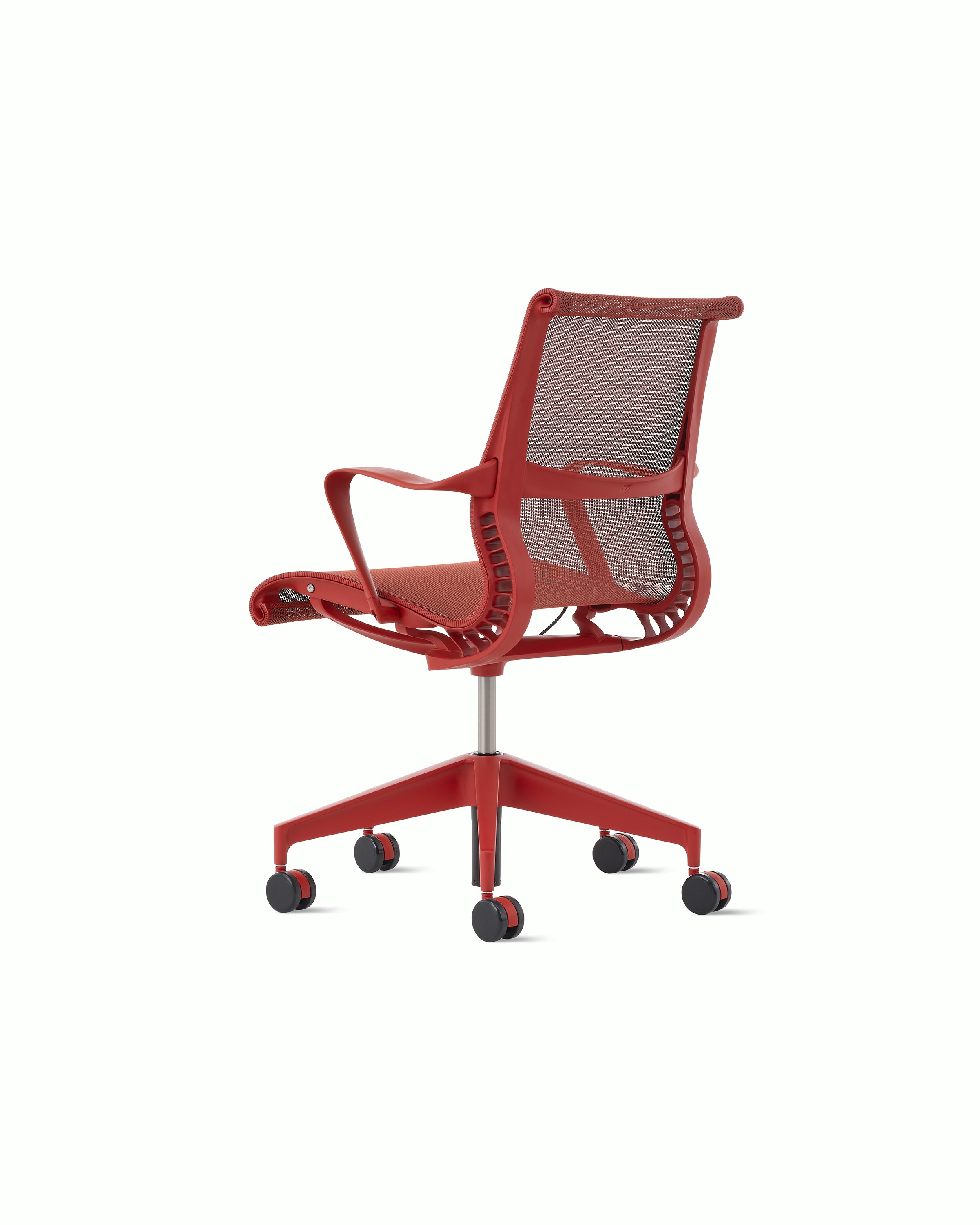 Rear angle view of a Setu chair with fixed arms in red.
