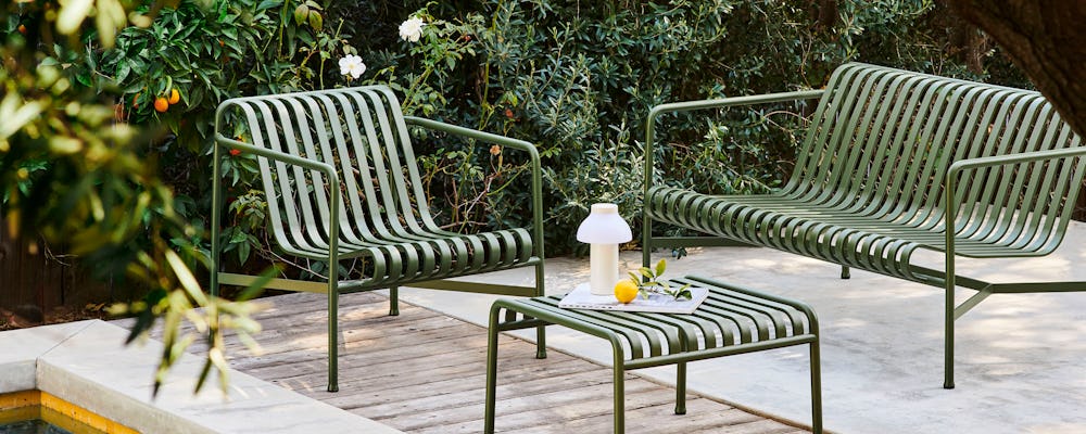 A Palissade Lounge Sofa, Palissade Ottoman, and Palissade Lounge Chair sitting poolside.