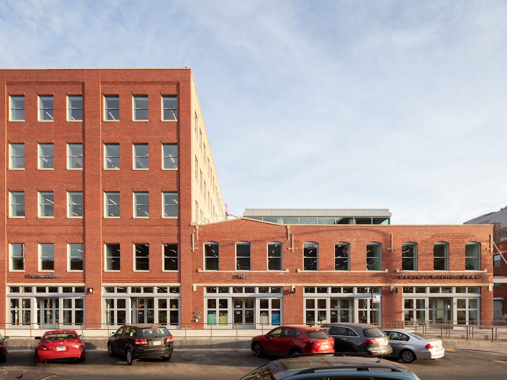 A straight-on view of the red brick exterior of the Herman Miller Group Fulton Market Showroom on a sunny afternoon.